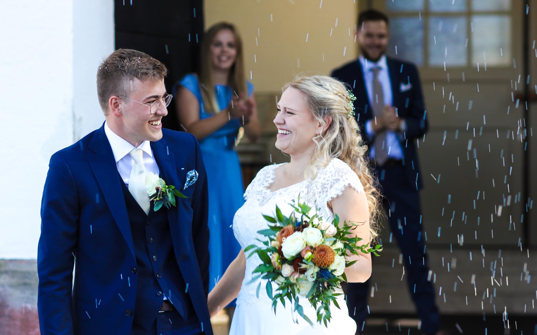 Bröllopspar i vitt konfettiregn