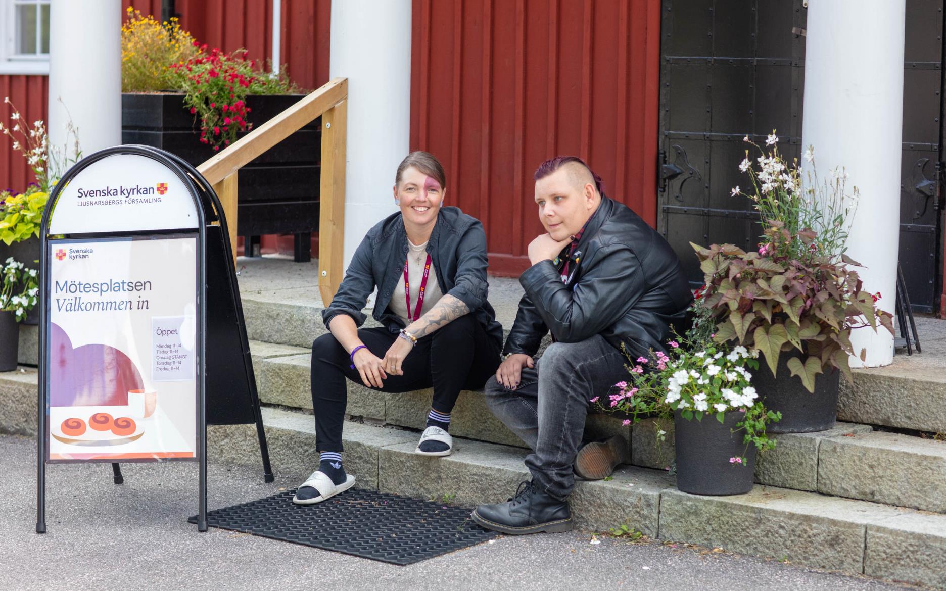 Två personer sitter utanför Mötesplatsens ingång i Kopparberg. 