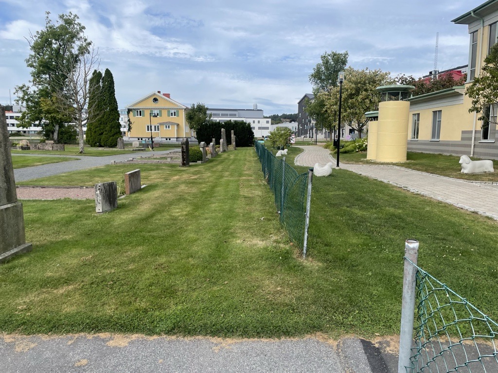 Miljöbild på kyrkogård, ett gammalt staket.