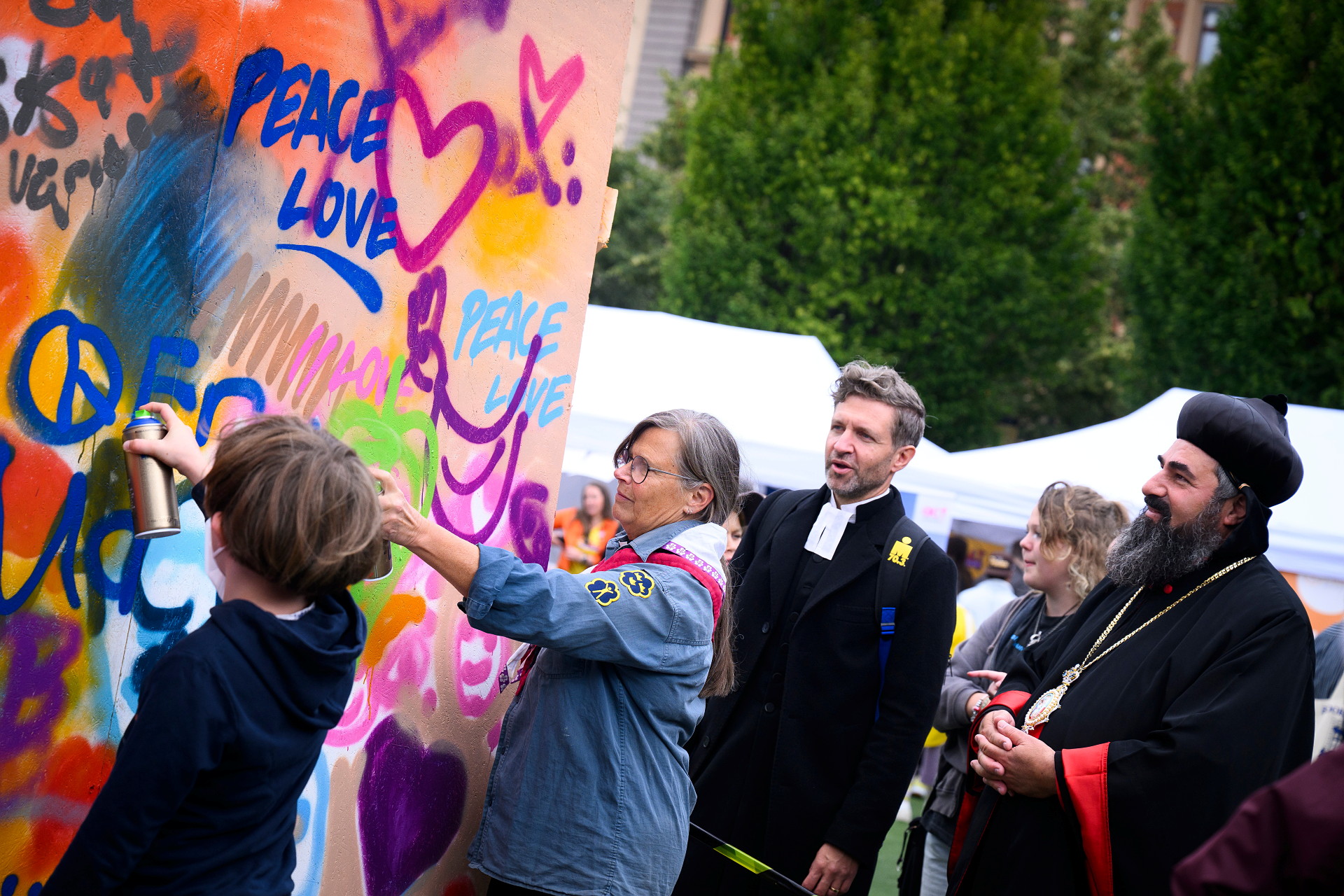 människor målar grafitti på en vägg