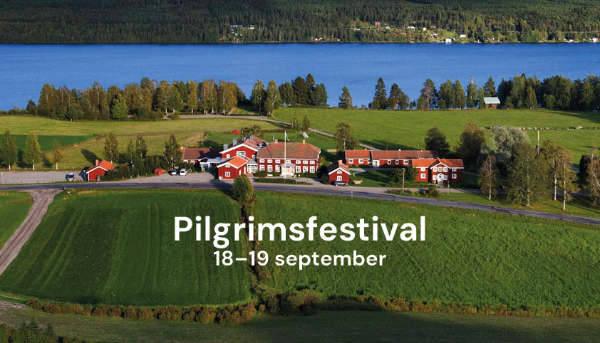Bild på gård på landsbygden. Sjö och skog i bakgrunden.