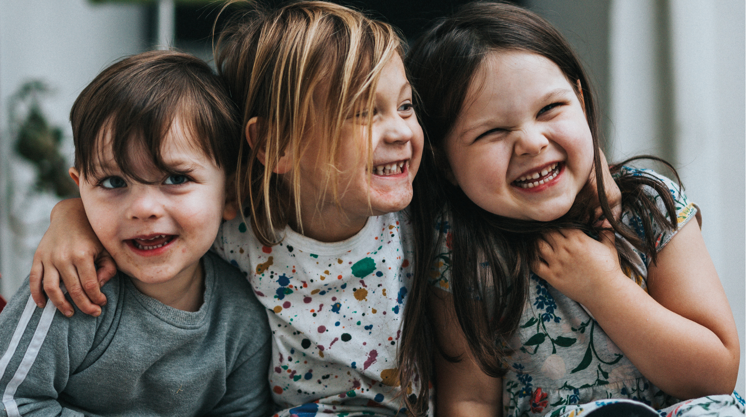 Tre barn som ler.