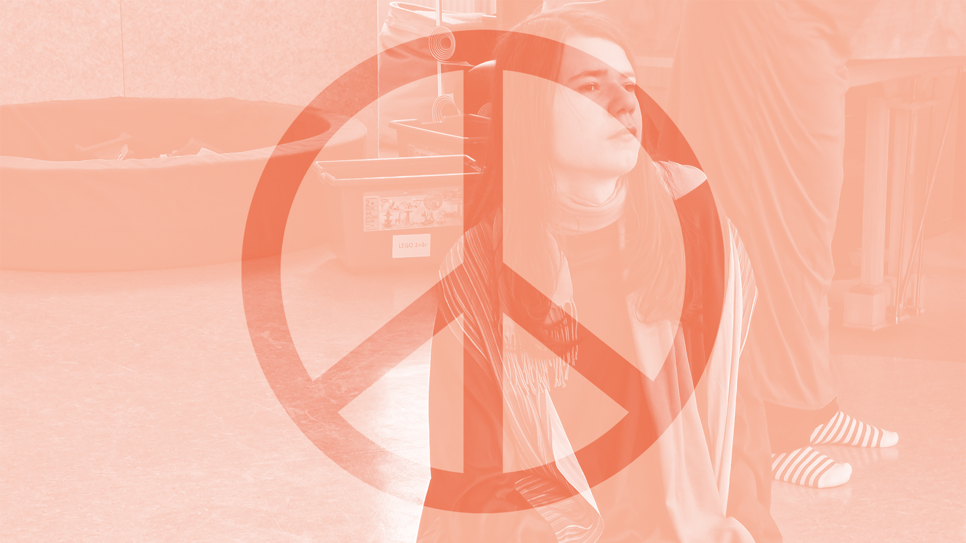 En bild av en skådespelare i musikalen. Över hen finns ett peace-tecken.
