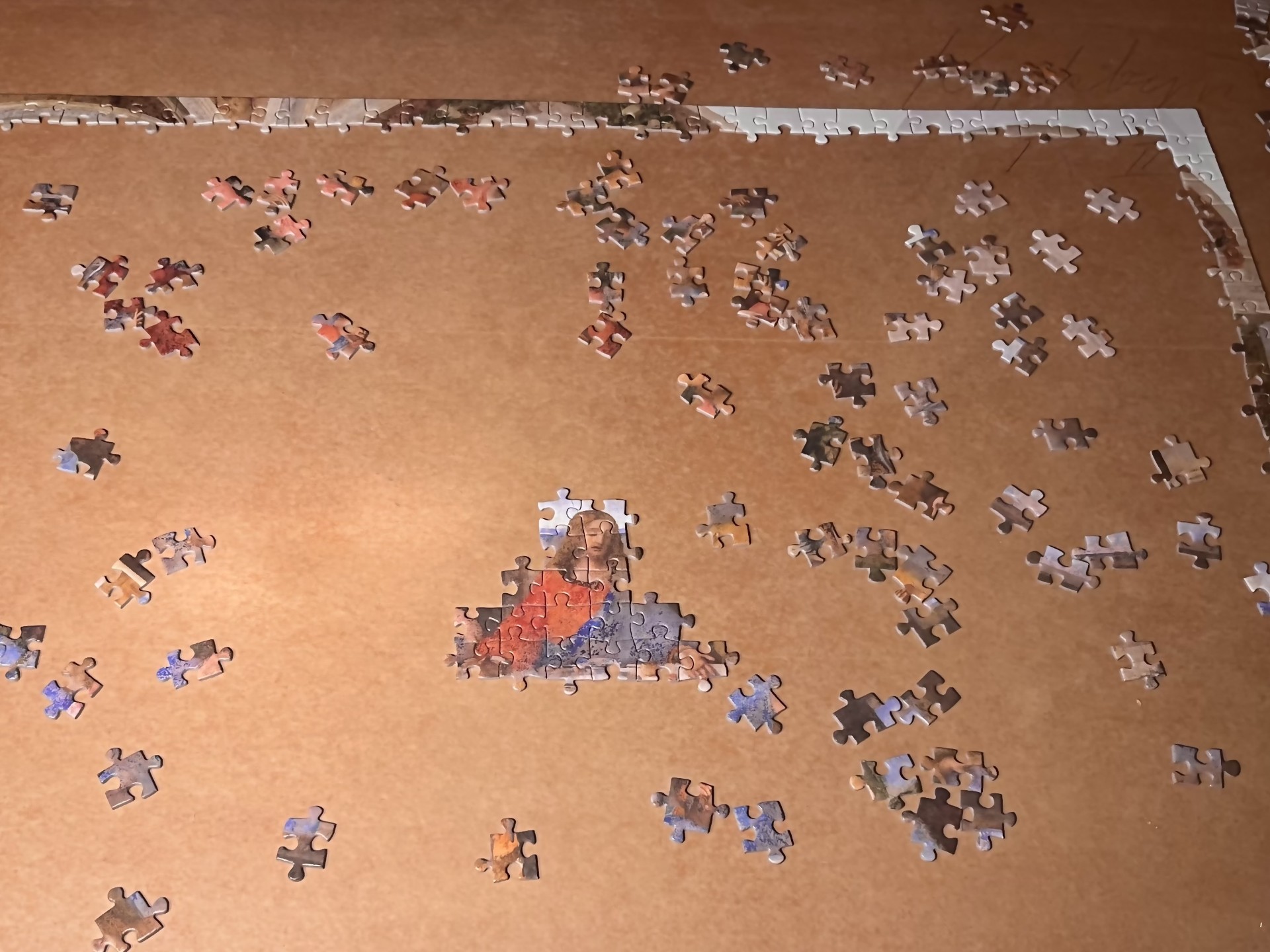 Bilden föreställer ett inte färdiglagt pussel. Motivet är 'Den sista måltiden'. Ramen är klar och i mitten är bitarna ihopsatta och visar Jesus. 