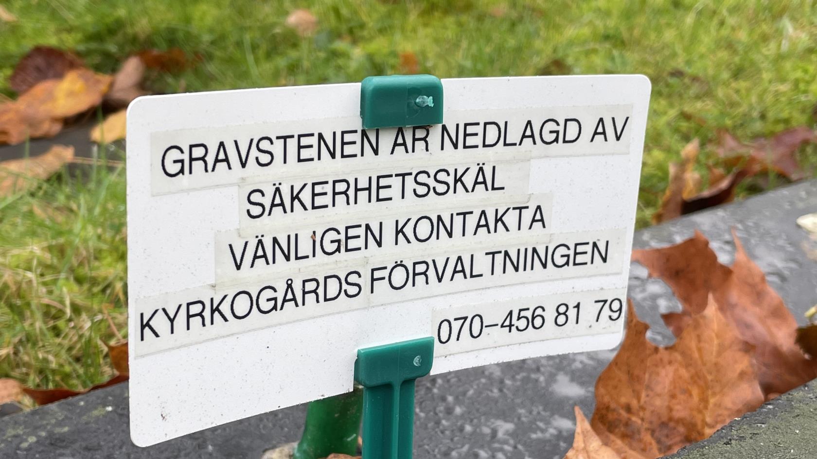 Skylt som syns vid stensäkrade gravar med följande text: Gravstenen är nedlagd av säkerhetsskäl. Vänligen kontakta kyrkogårdsförvaltningen 070-456 81 79.