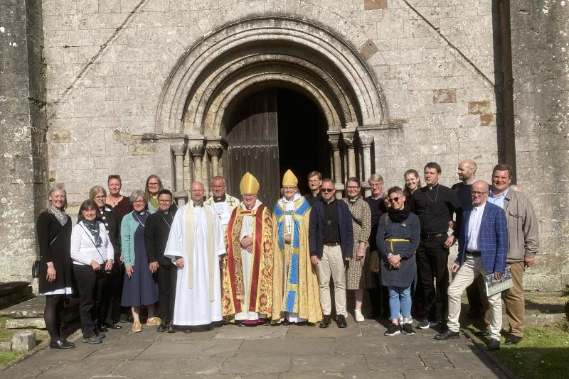 En grupp människor framför kyrkan Margam abbey i Wales