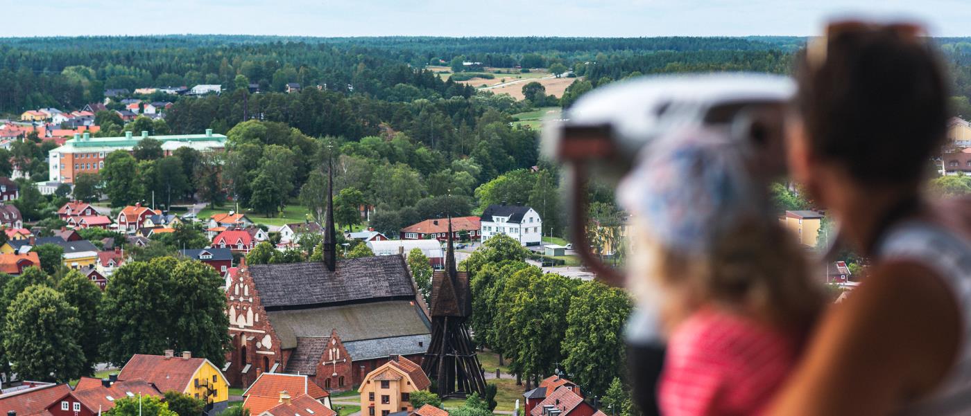 Två suddiga personer tittar ut över ett samhälle från en höjd