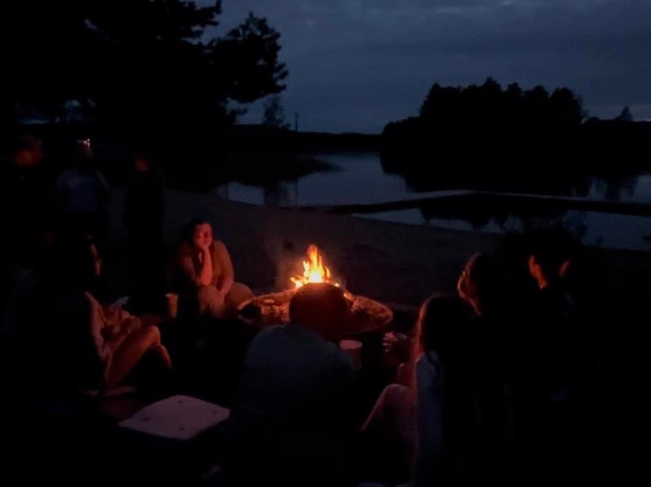 Ungdomar runt en lägereld under en sensommarkväll