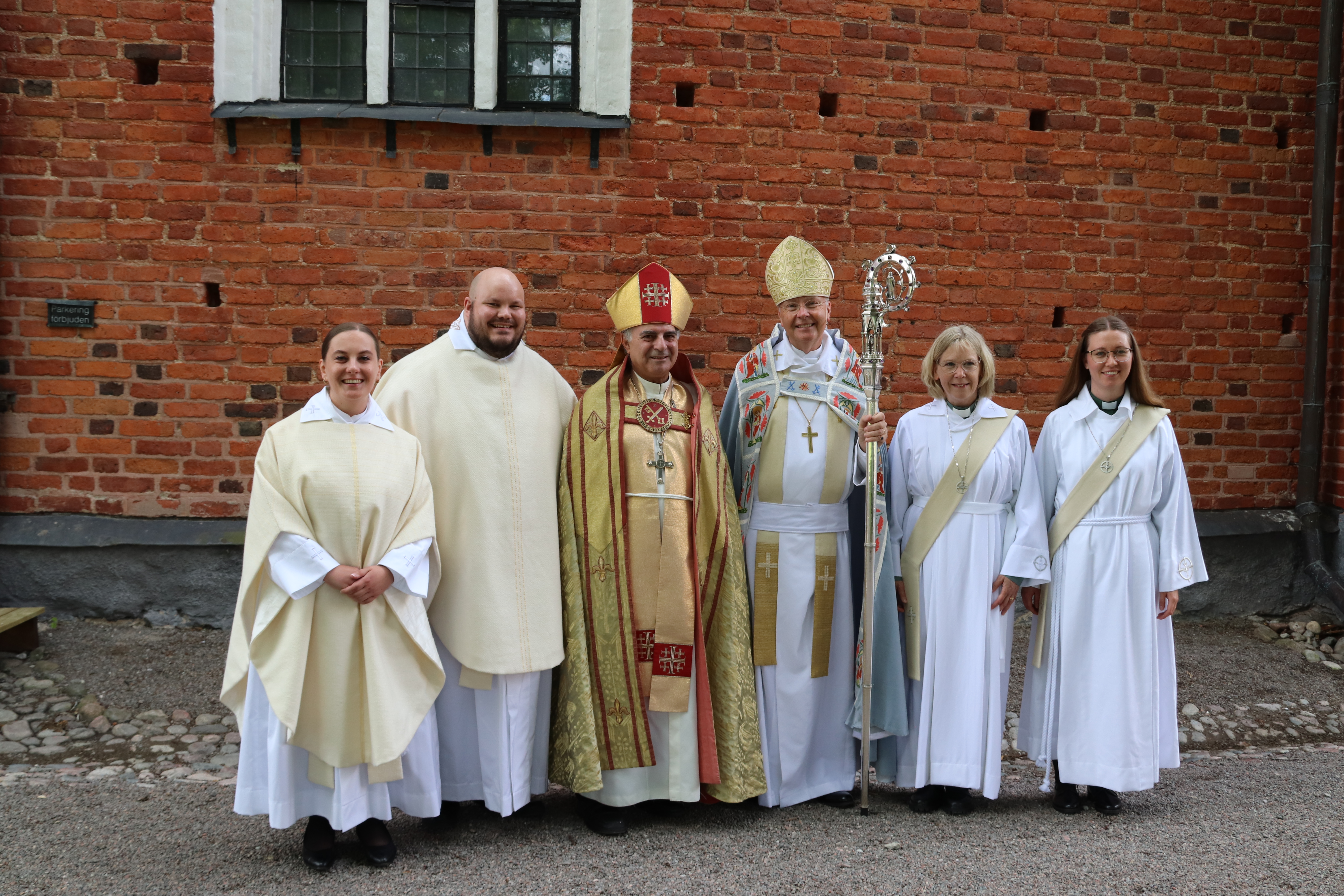 Pilgrimsvandrare äter lunch vid en gammal ruin invid ett träkors