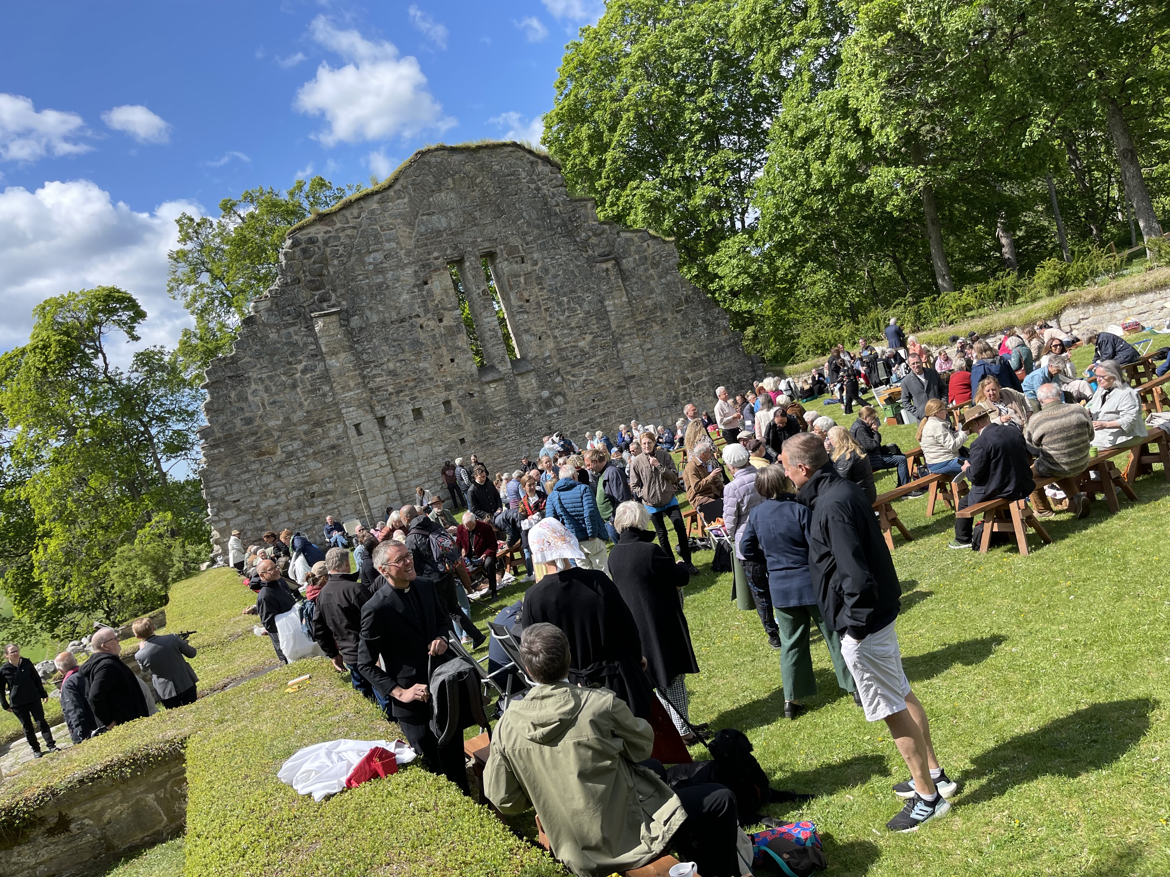 Människor samlas för gudstjänst i klosterruin