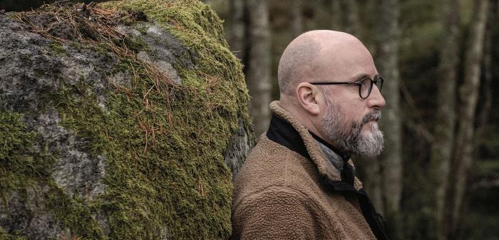 Peter Gembäck, tidigare pastor i Knutby pingstförsamling, står med ryggen mot en stor sten.