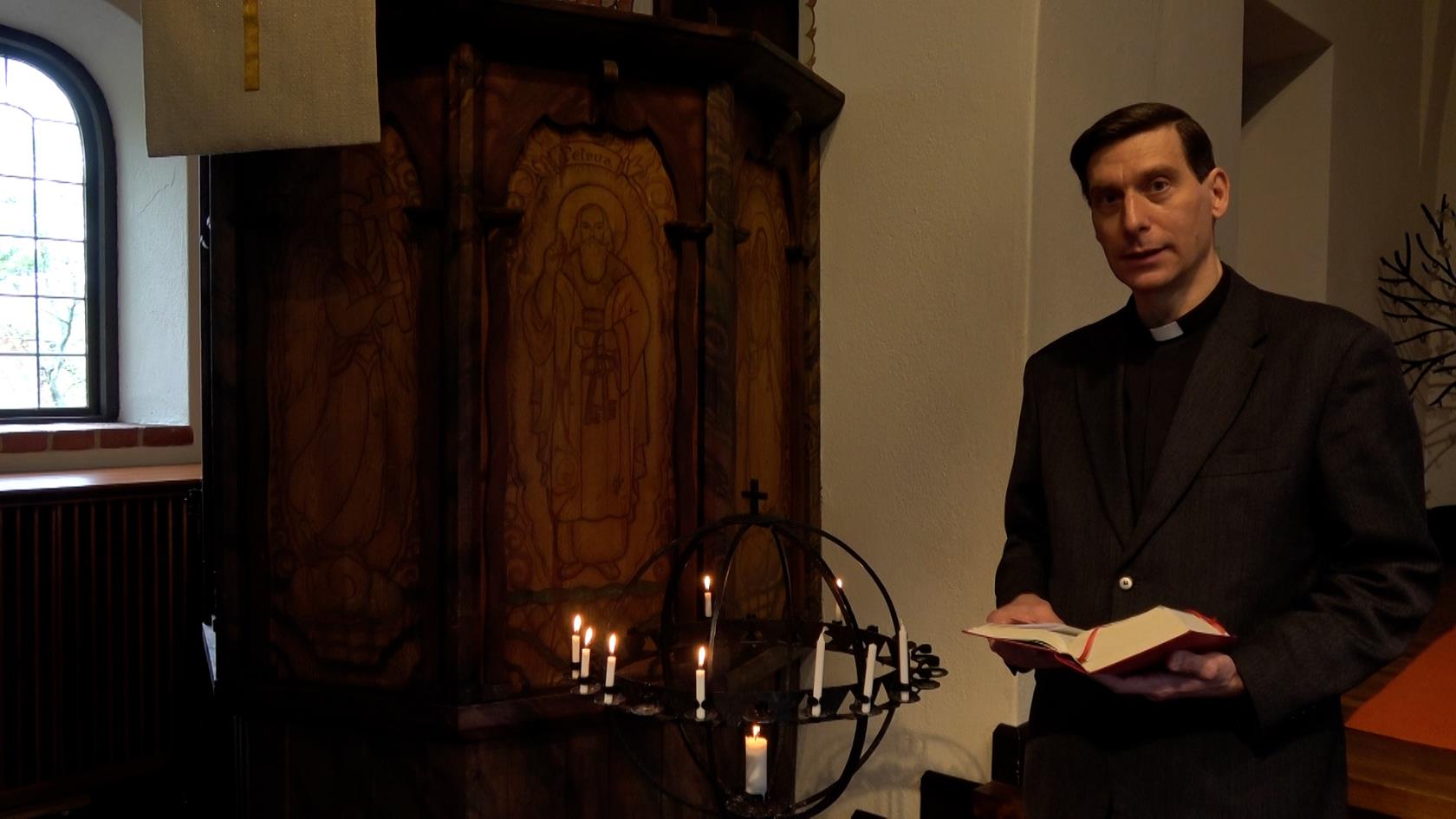 Prästen Stefan Gaspar vid ljusbäraren i Enskede kyrka