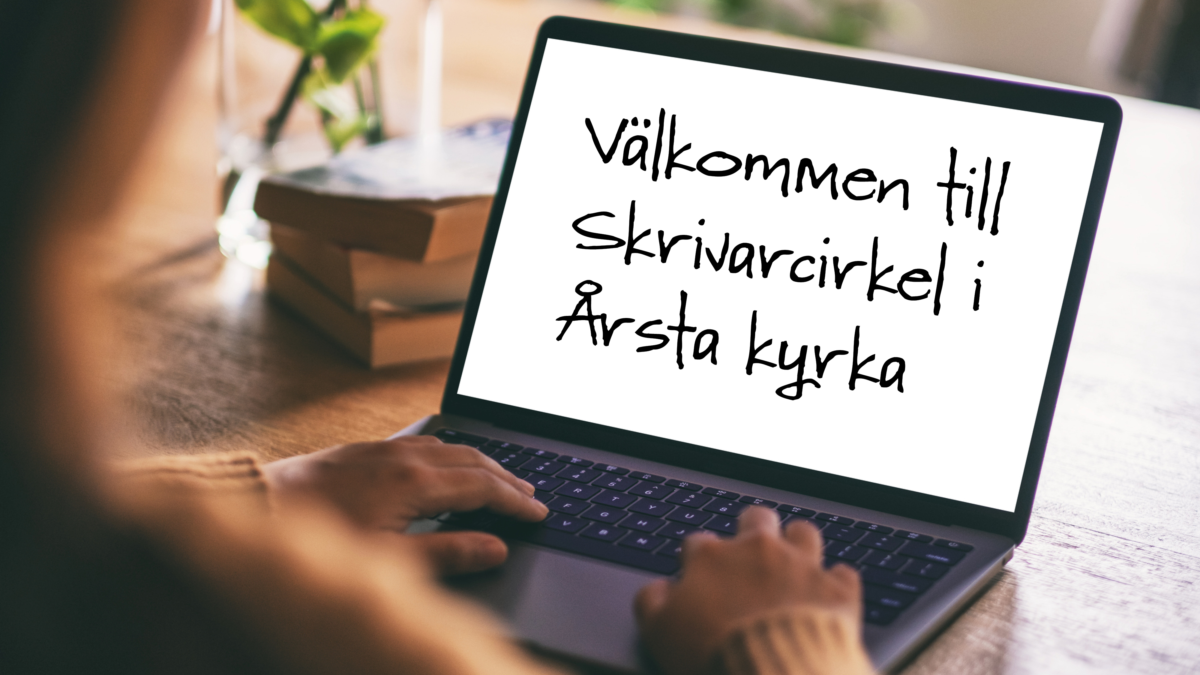 En person sedd bakifrån som sitter och skriver på en laptop