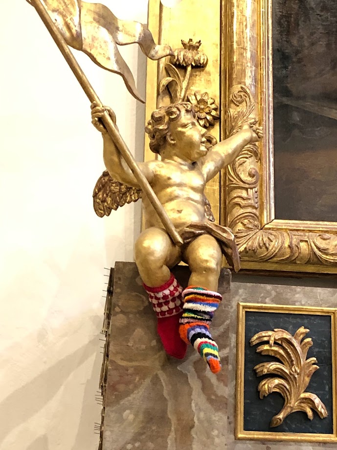 En förgylld änglastaty har fått randiga raggsockor på sina fötter.