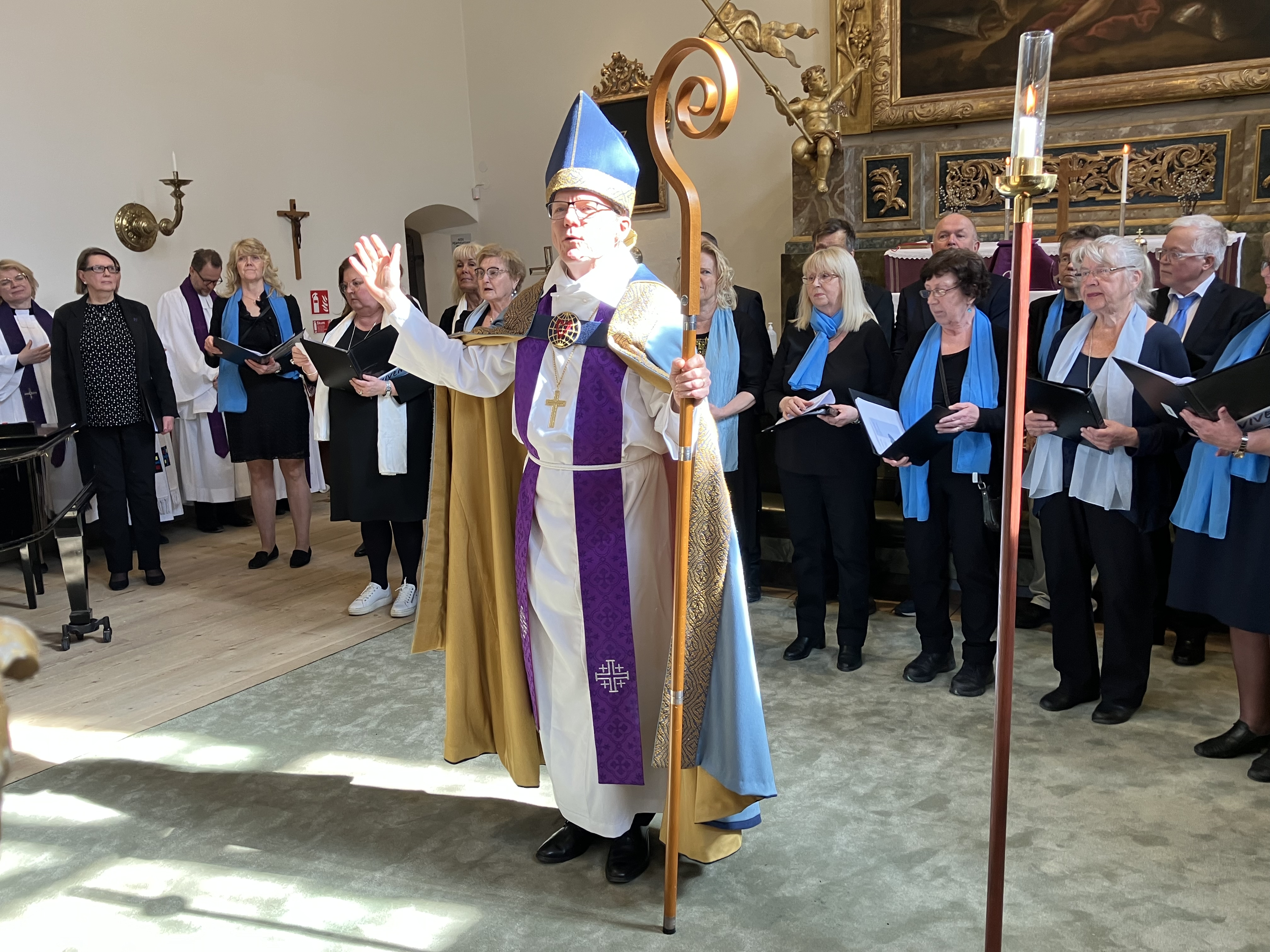 Biskop håller i staven och välsignar församlingen.