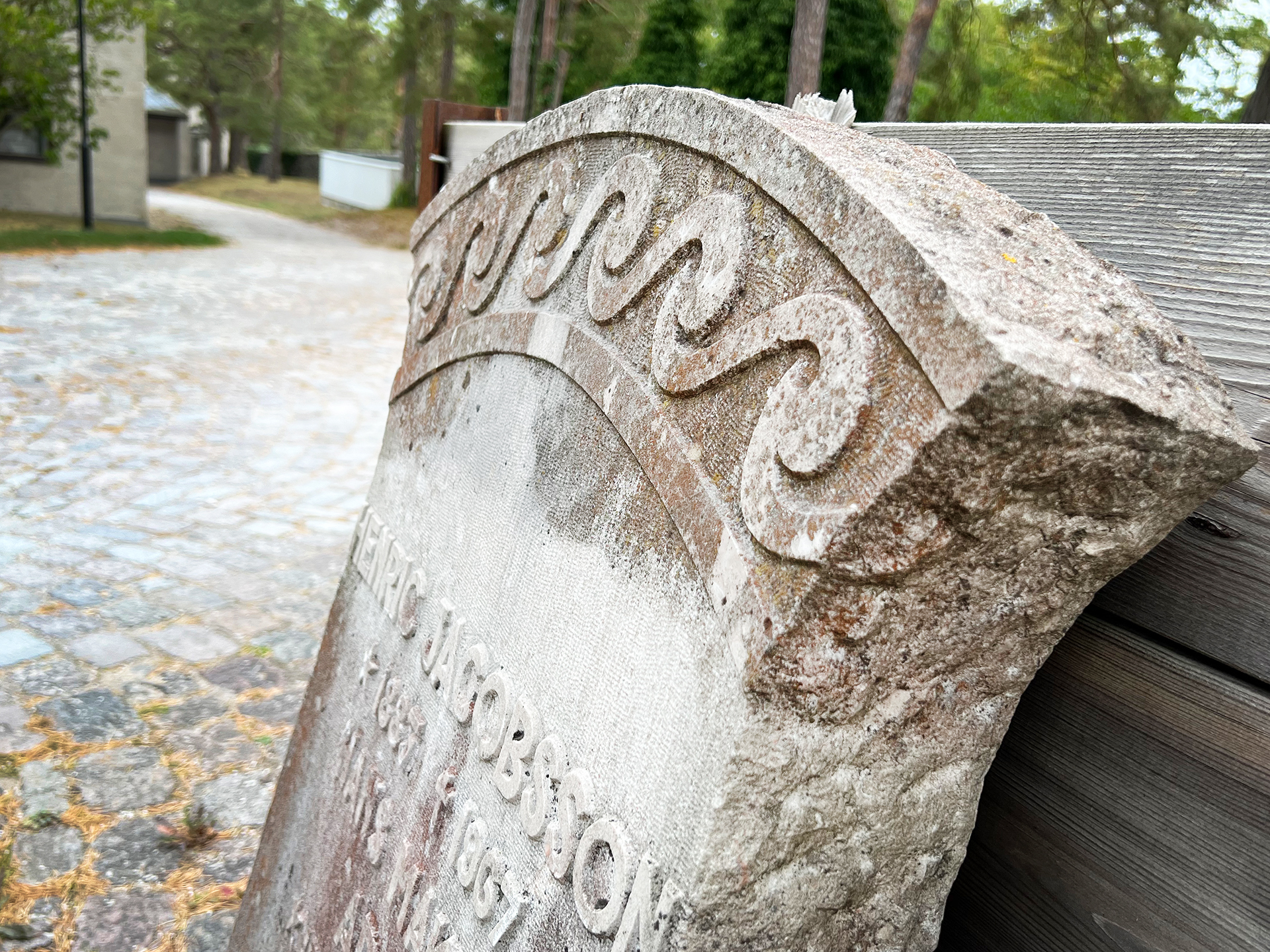 Gravsten lutad mot plank