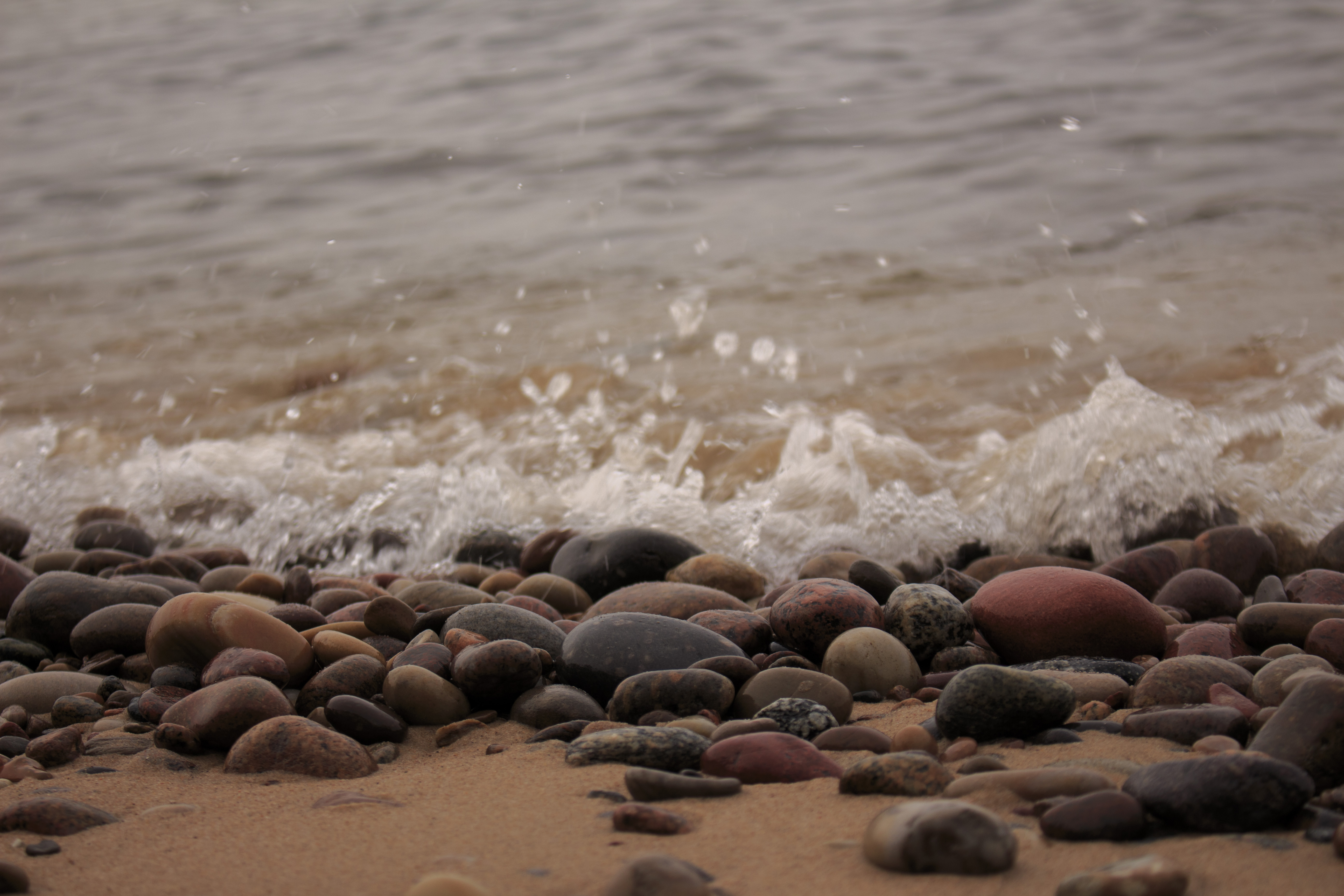 Stenig strand med vatten i bakgrunden