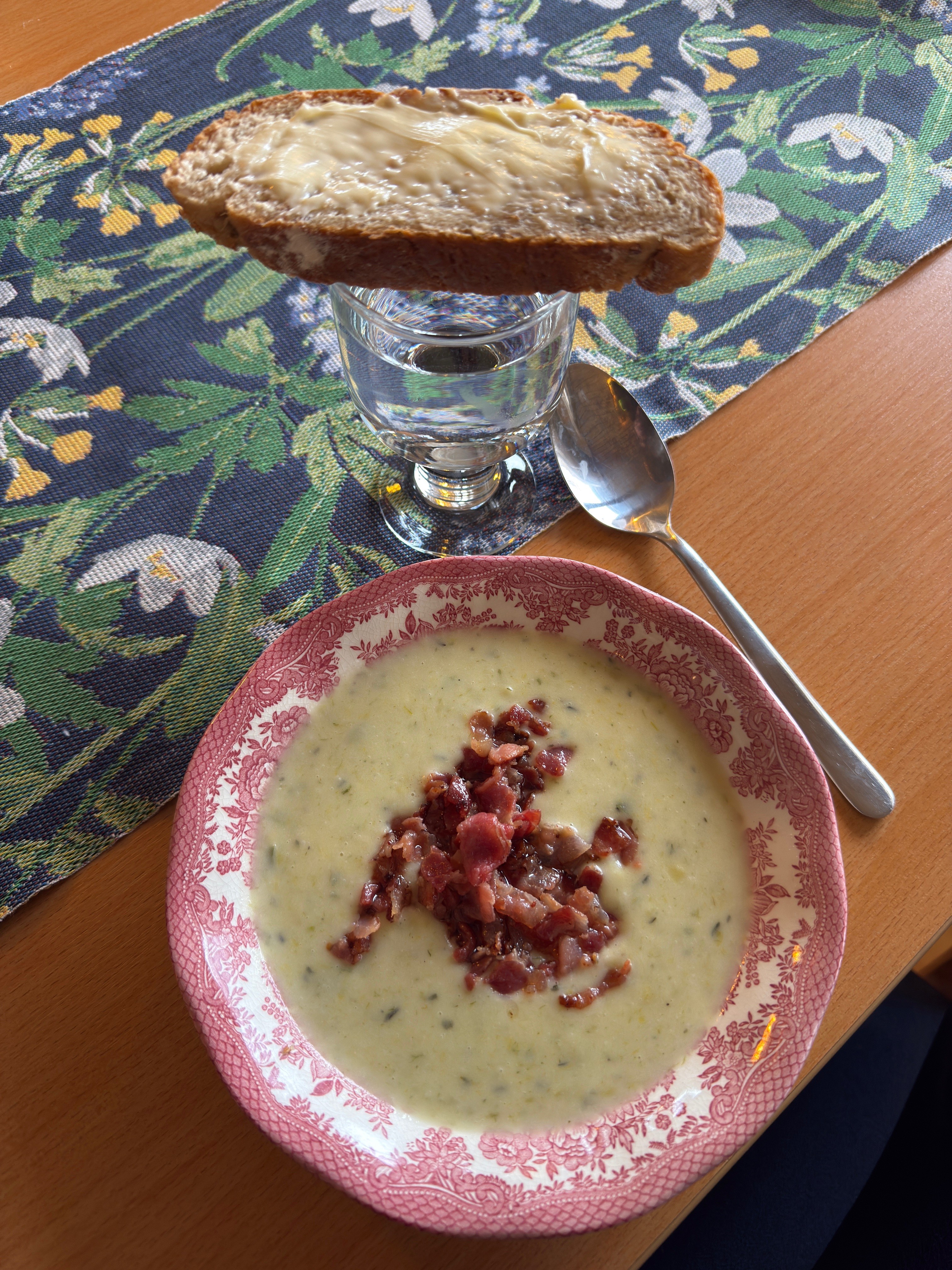 Tallrik med soppa. Vattenglas med brödskiva ovanpå.