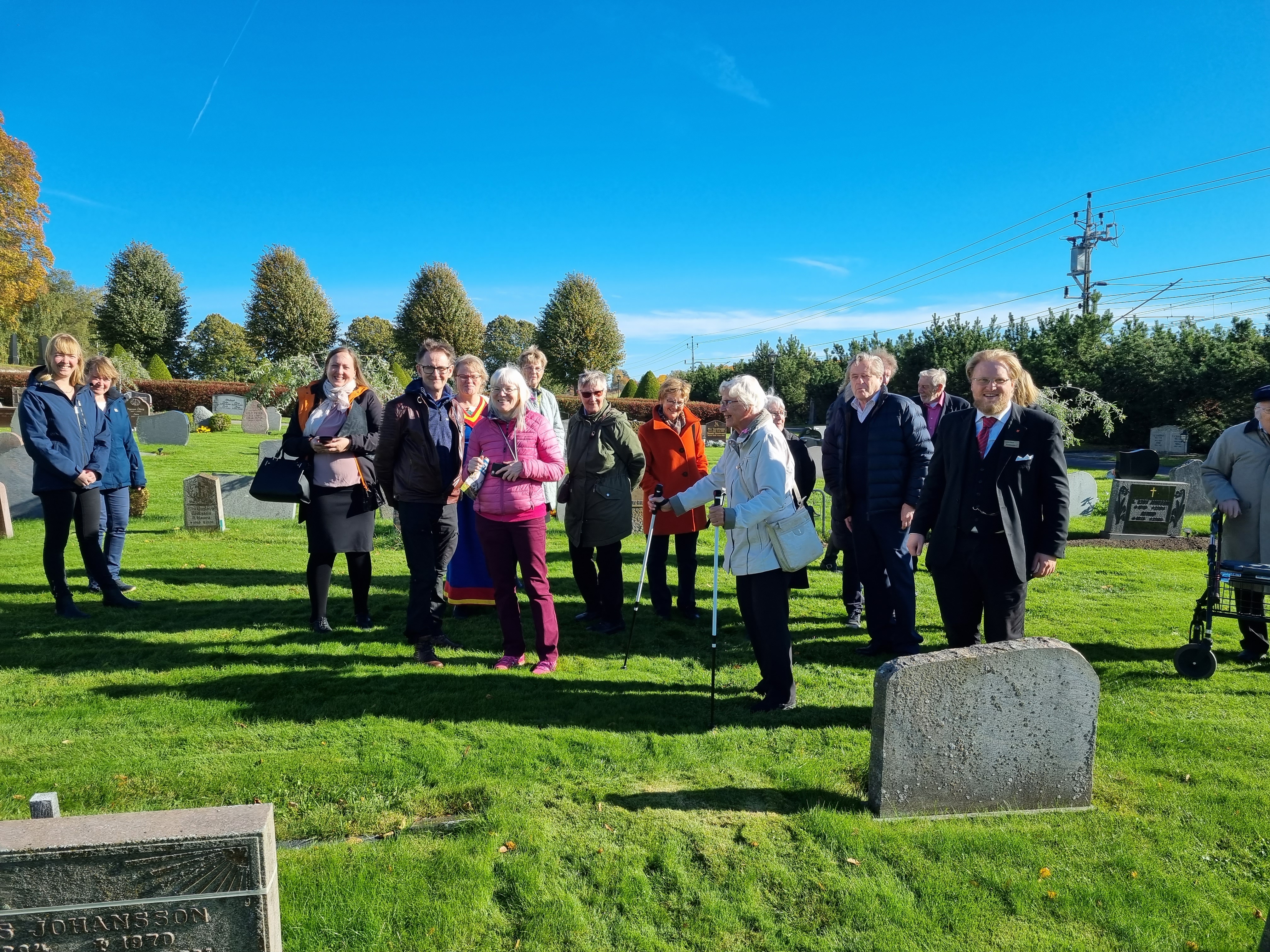 En grupp människor tittar på gravstenar vid Sockenkyrkan