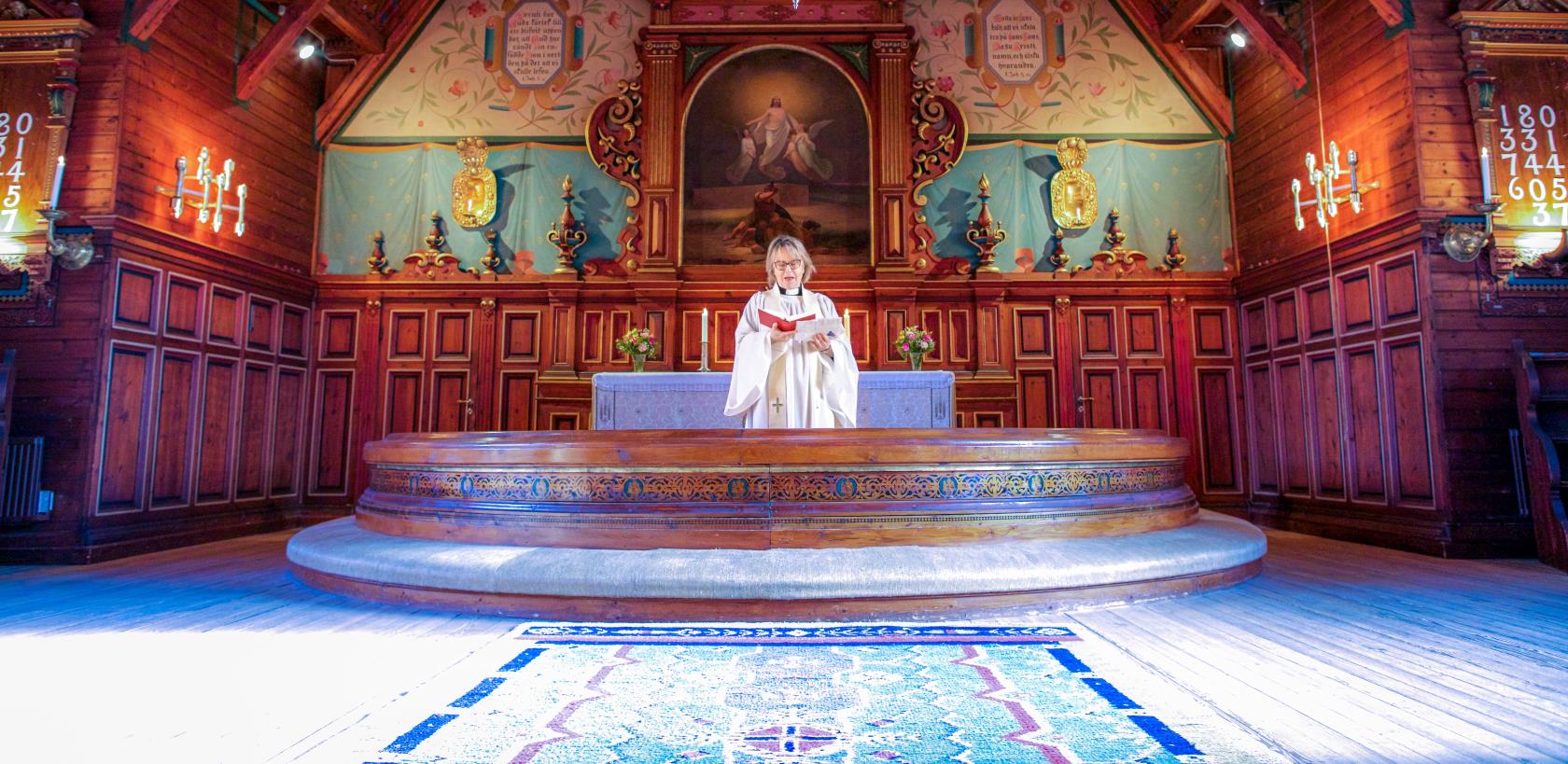 Präst vid altaret Ljusnarsbergs kyrkan