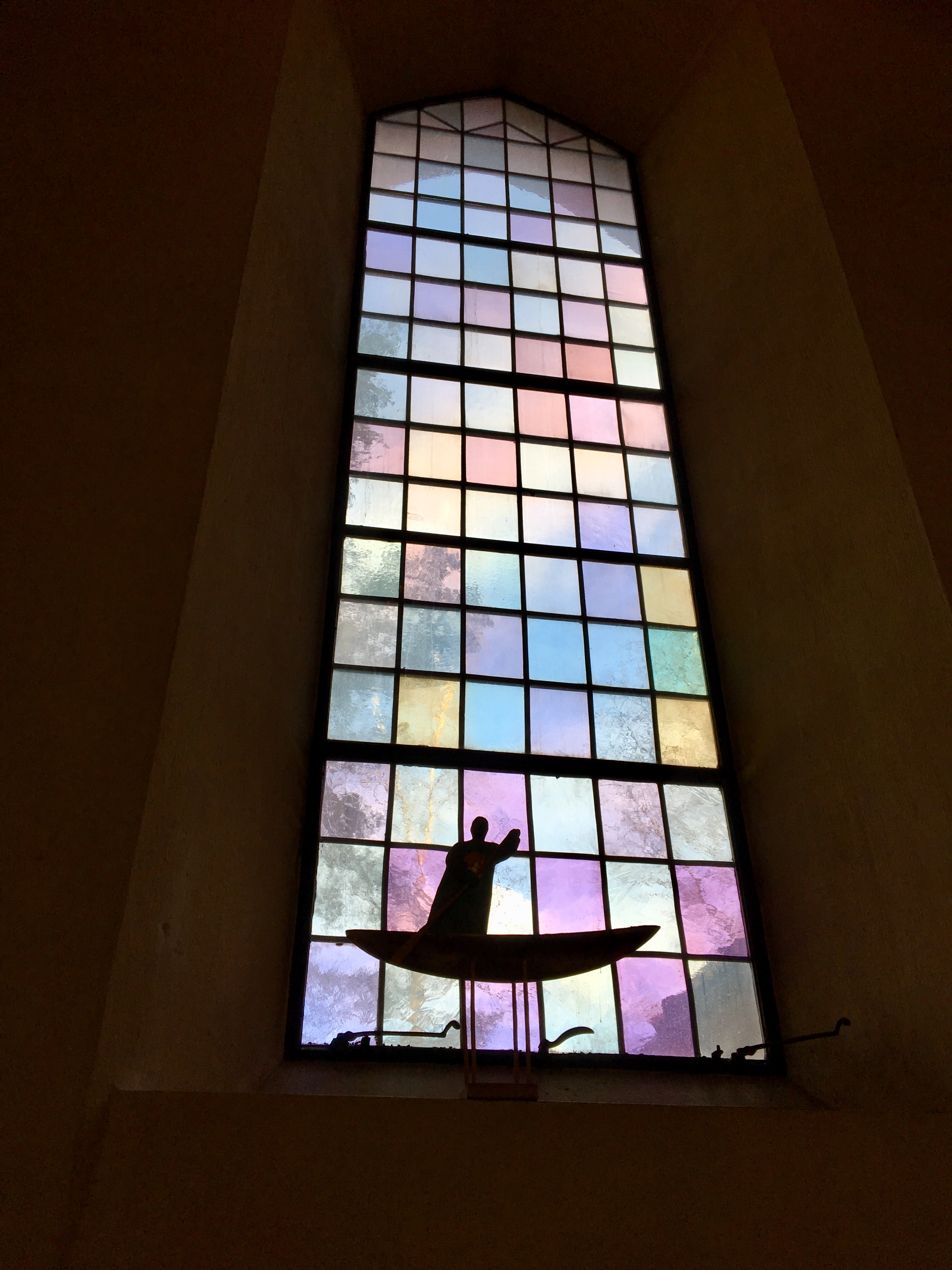 Skulptur i ett kyrkfönster, föreställande Jesus som står i en båt