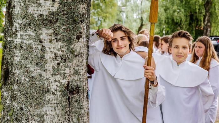 Konfirmander i kåpor vid konfirmationsgudstjänst.