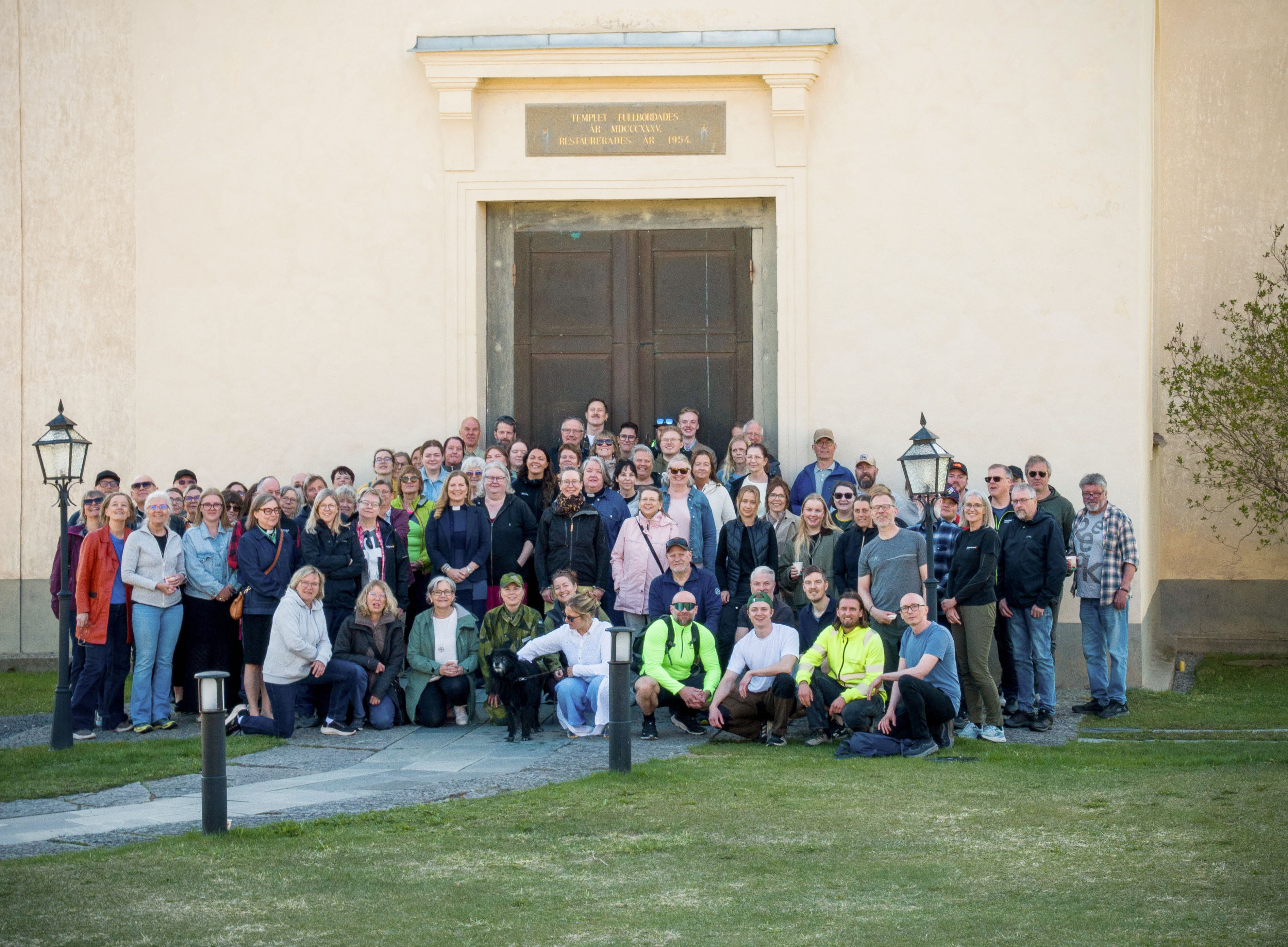Gruppbild, personal utanför kyrkport i Sunne.