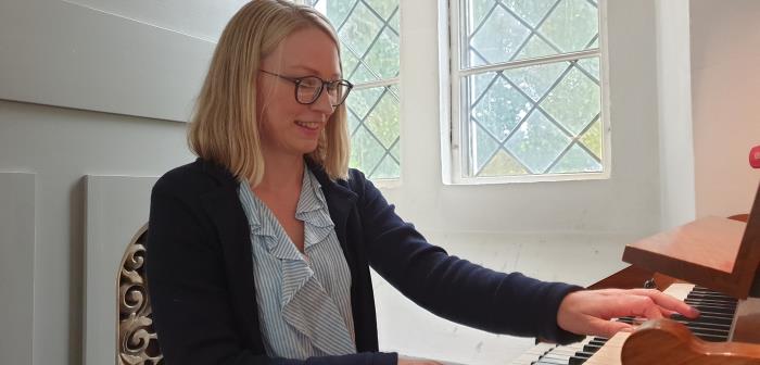 Pernilla Vikström ler och spelar på orgeln.