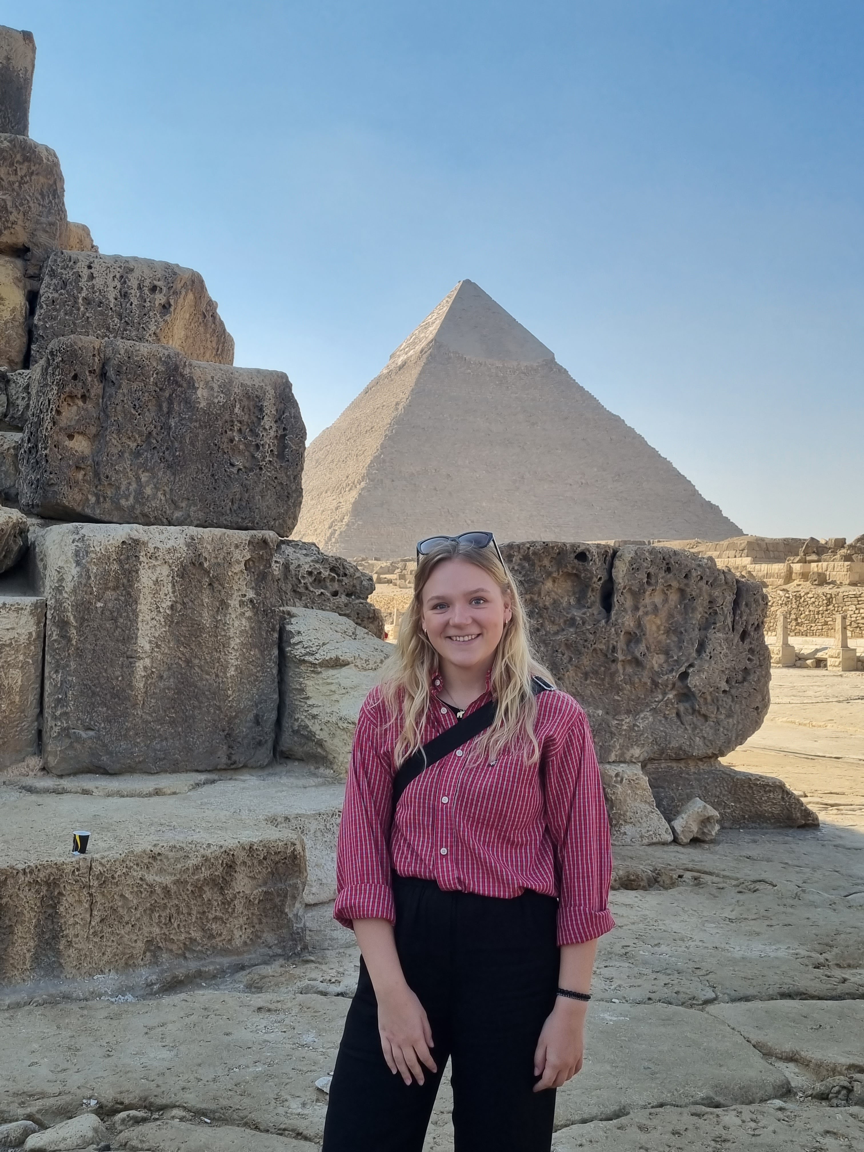 Ung, leende kvinna framför pyramiderna.