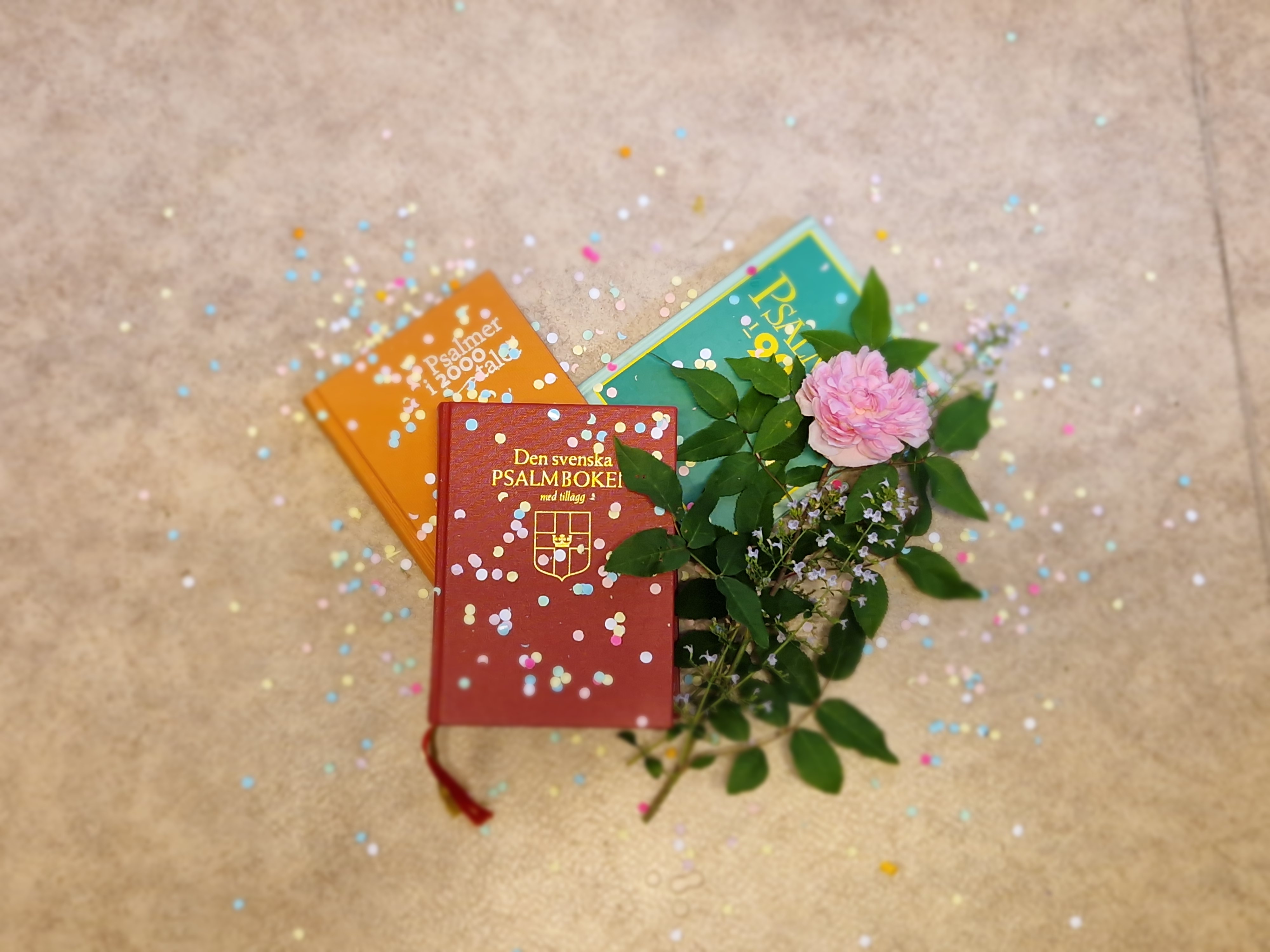 Psalmböcker av olika slag med blommor och konfetti.
