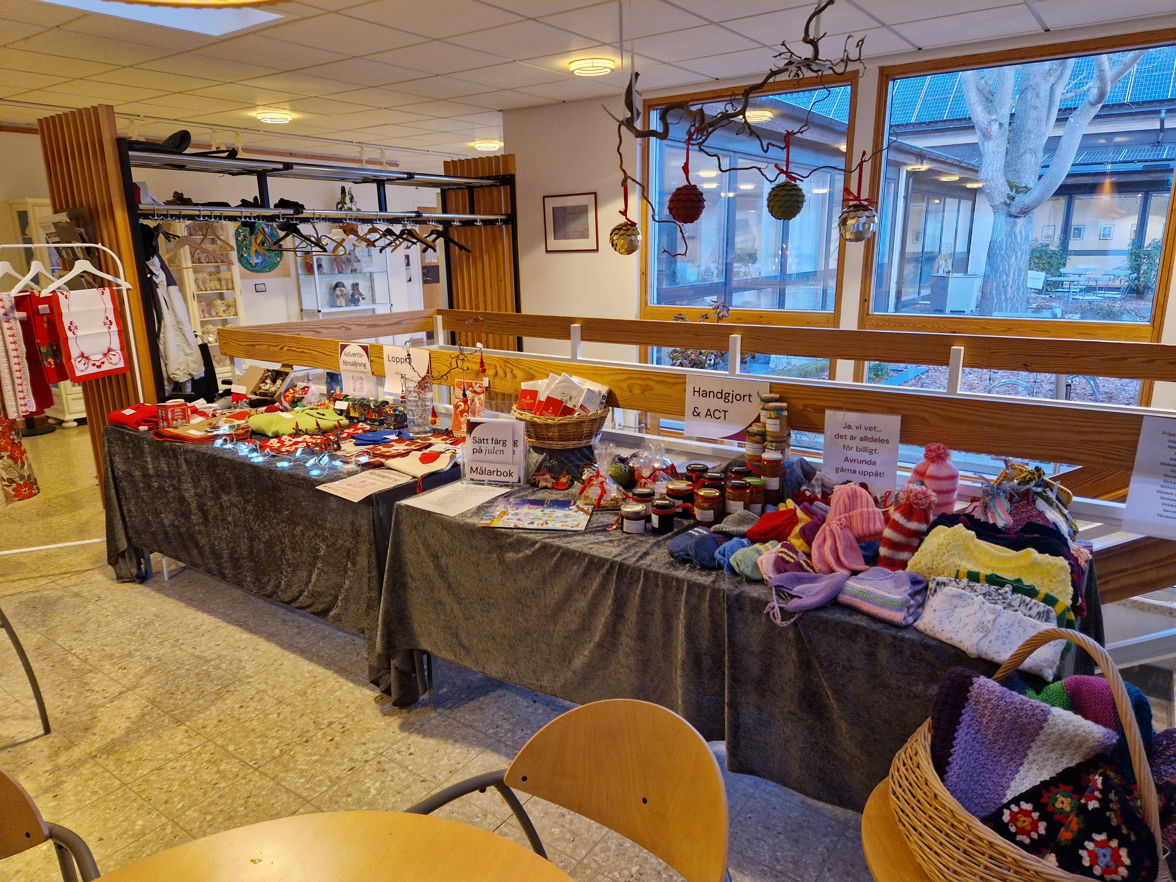 Ett långt bord med många saker i församlingsgårdens foajé.