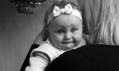 svartvit bild med baby som titta in i kameran