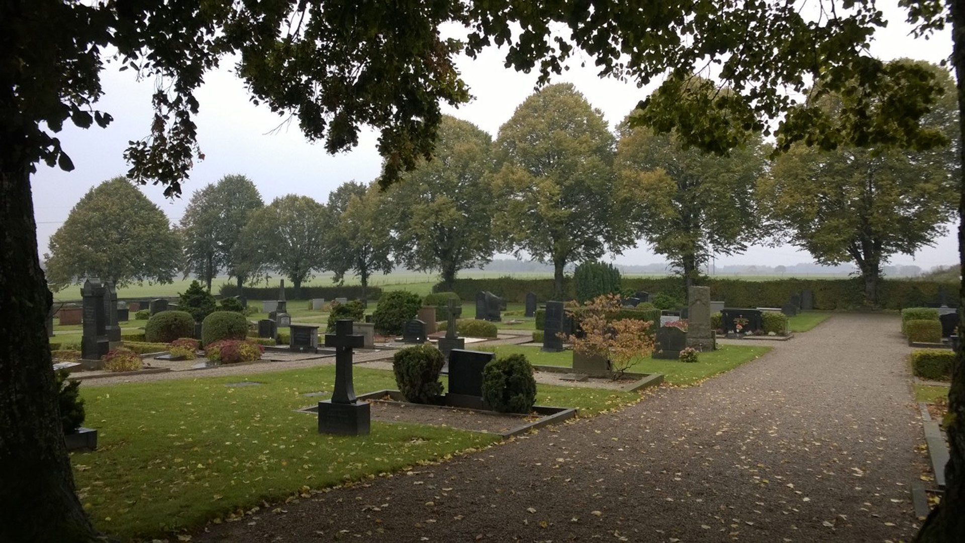 Smedstorps kyrkogård där höstlöven faller ner