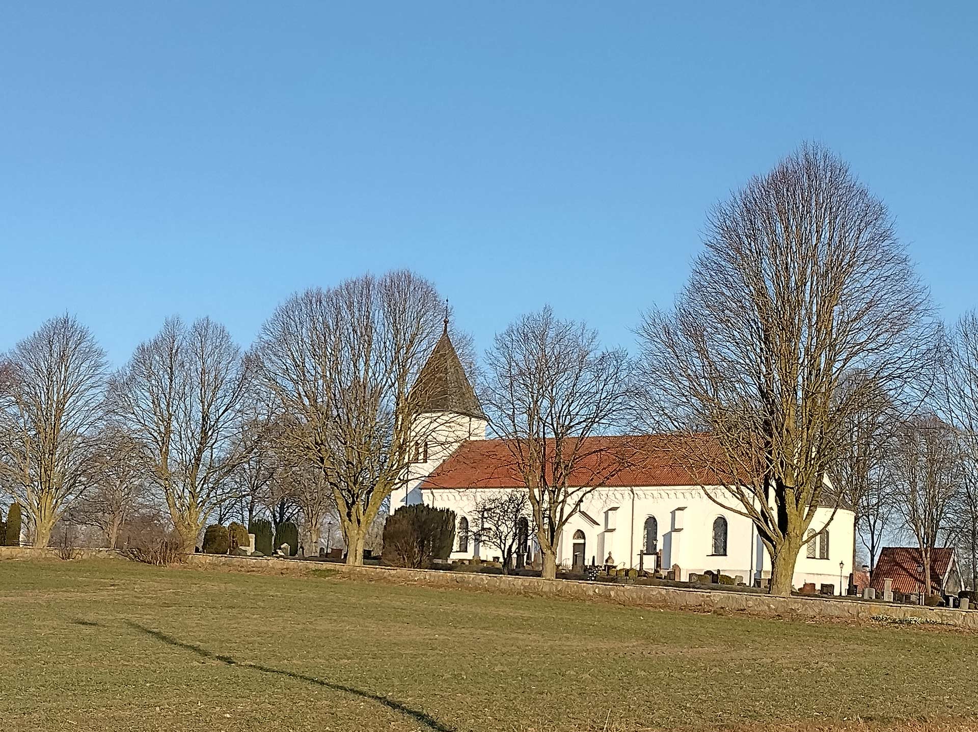 Morgonsolen lyser på Smedstorps kyrka i mars månad