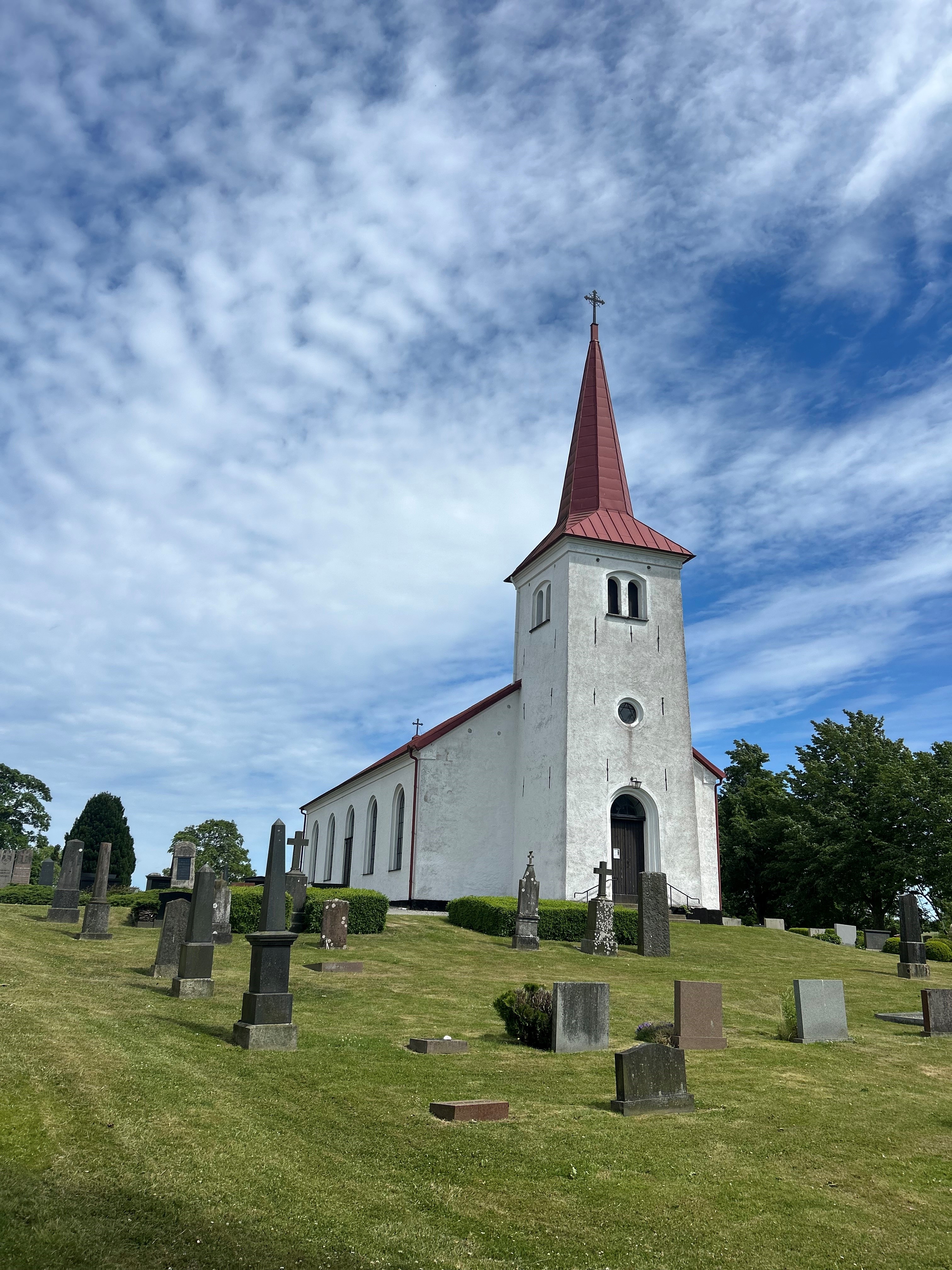 Vit kyrkobyggnad med rött tegeltak.