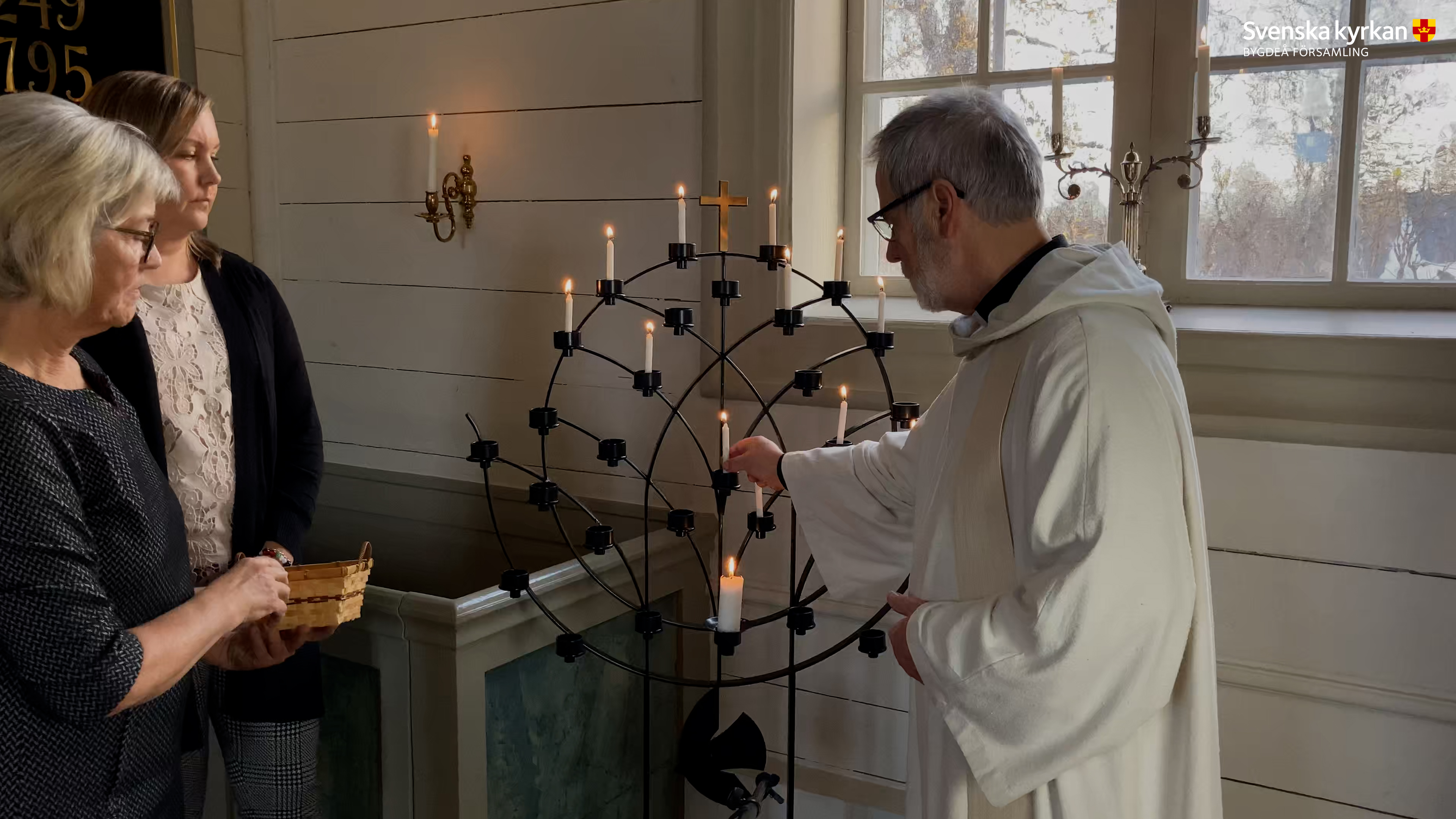 Kyrkoherde Sören Olsson tänder ett ljus i ljusbäraren i Nysätra kyrka.