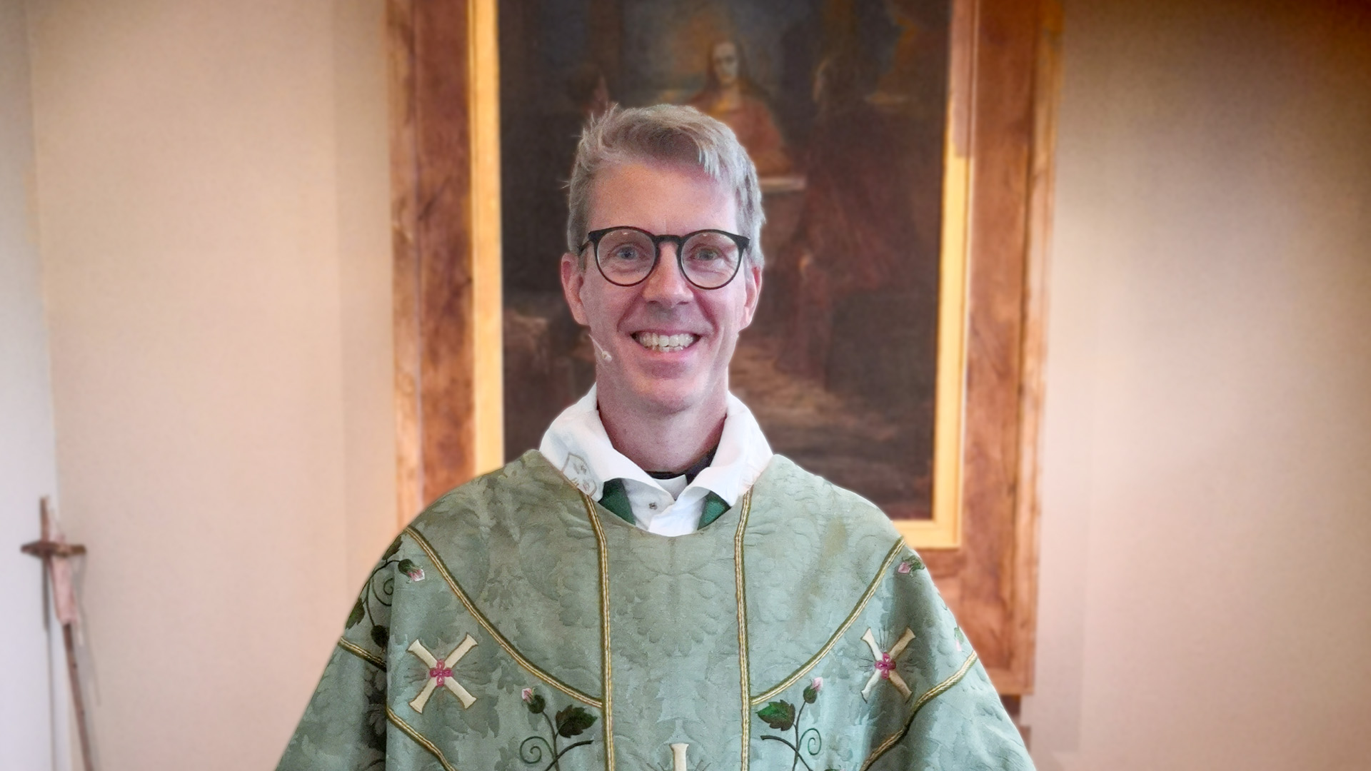 Kristoffer Hedman ler in i kameran. På sig har han en gammal mässhake från Homöns kyrka.