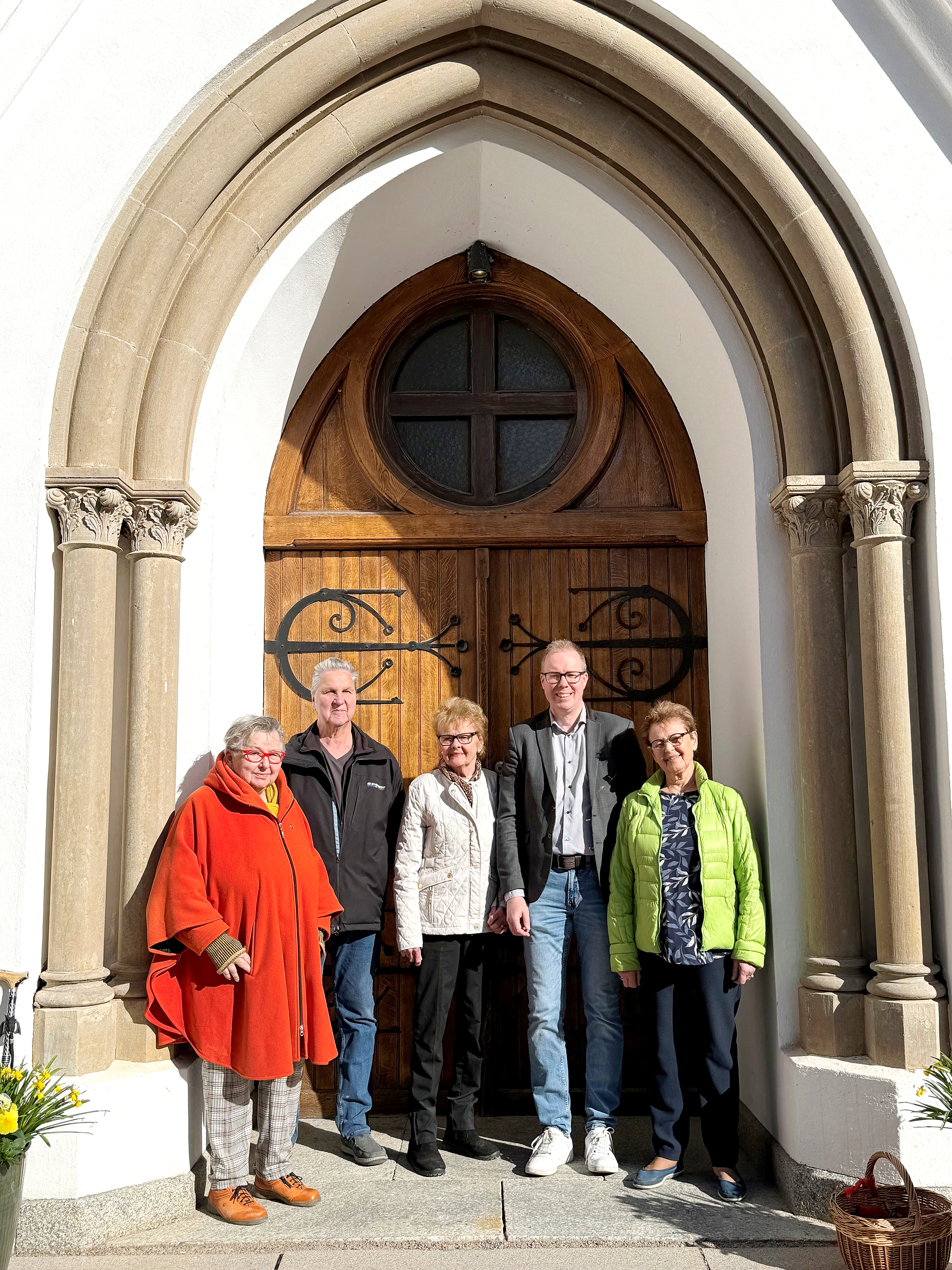 Fem personer står framför kyrkporten