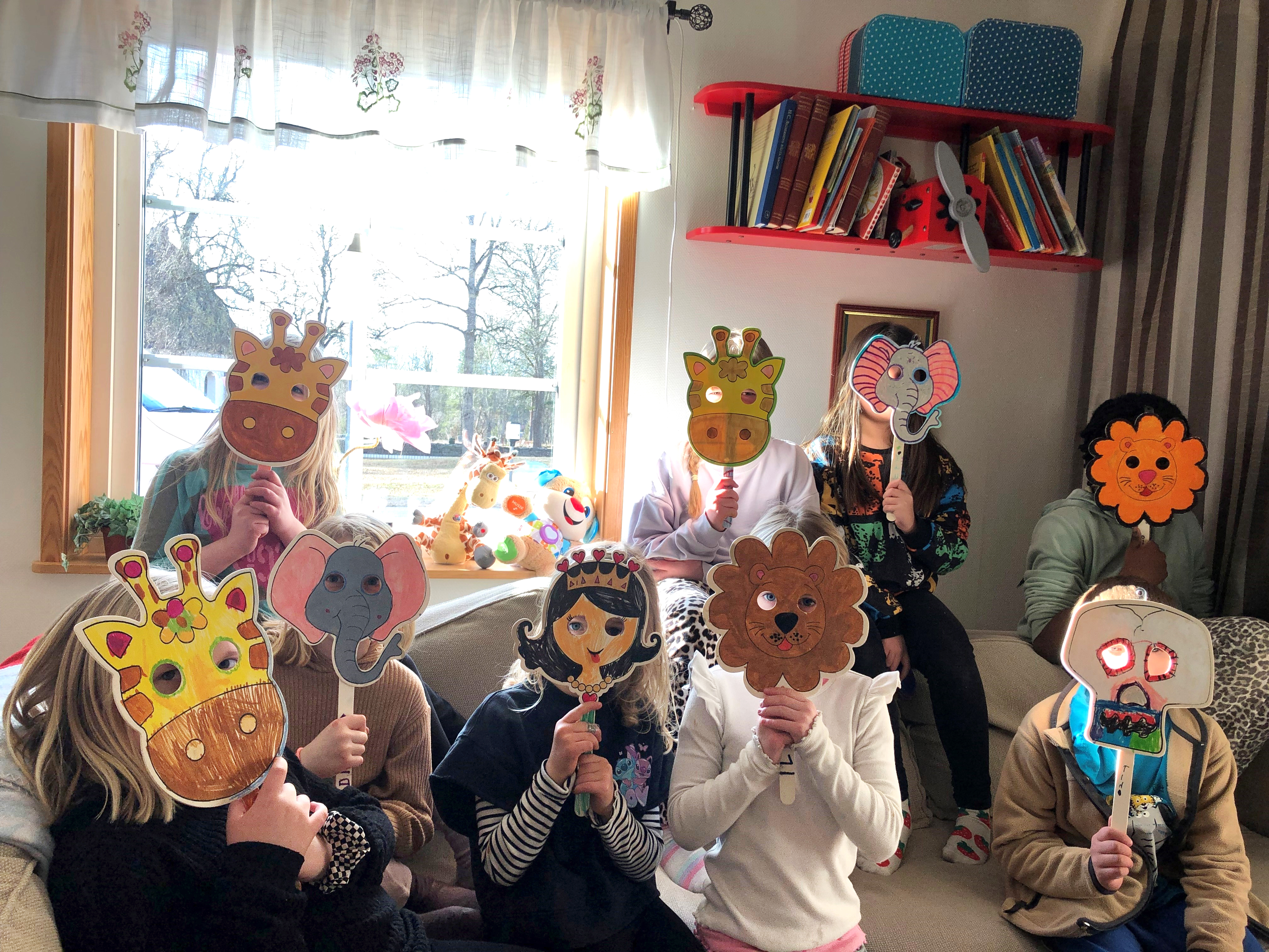 En grupp barn med pappersmasker framför ögonen.