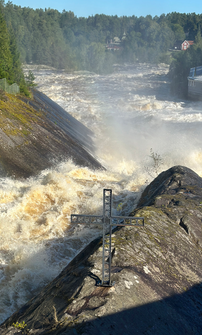 Ett kors på en klippa i ett vattenfall