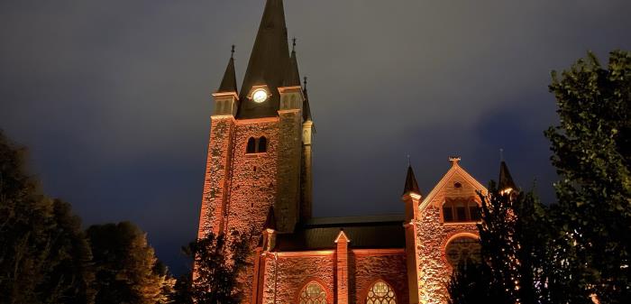 Domkyrkan vackert belyst med rött ljus upp mot fasaden.