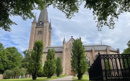 Mariestads domkyrka sedd från den södra långsidan en lummig sommardag.