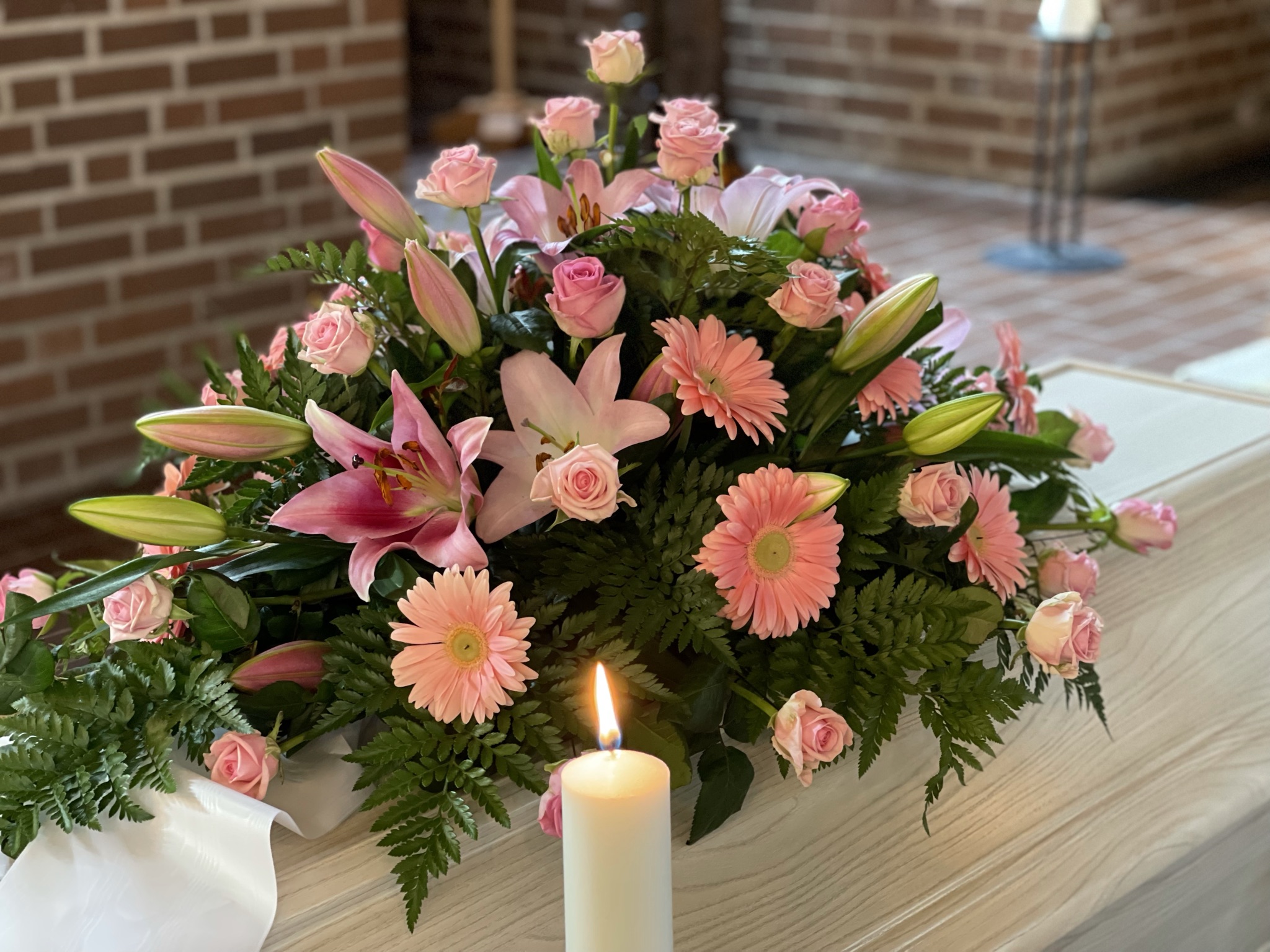 Rosa blommor på en vit kista.