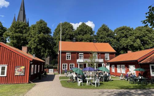 Cafébord i prästgårdsträdgården en solig sommardag.