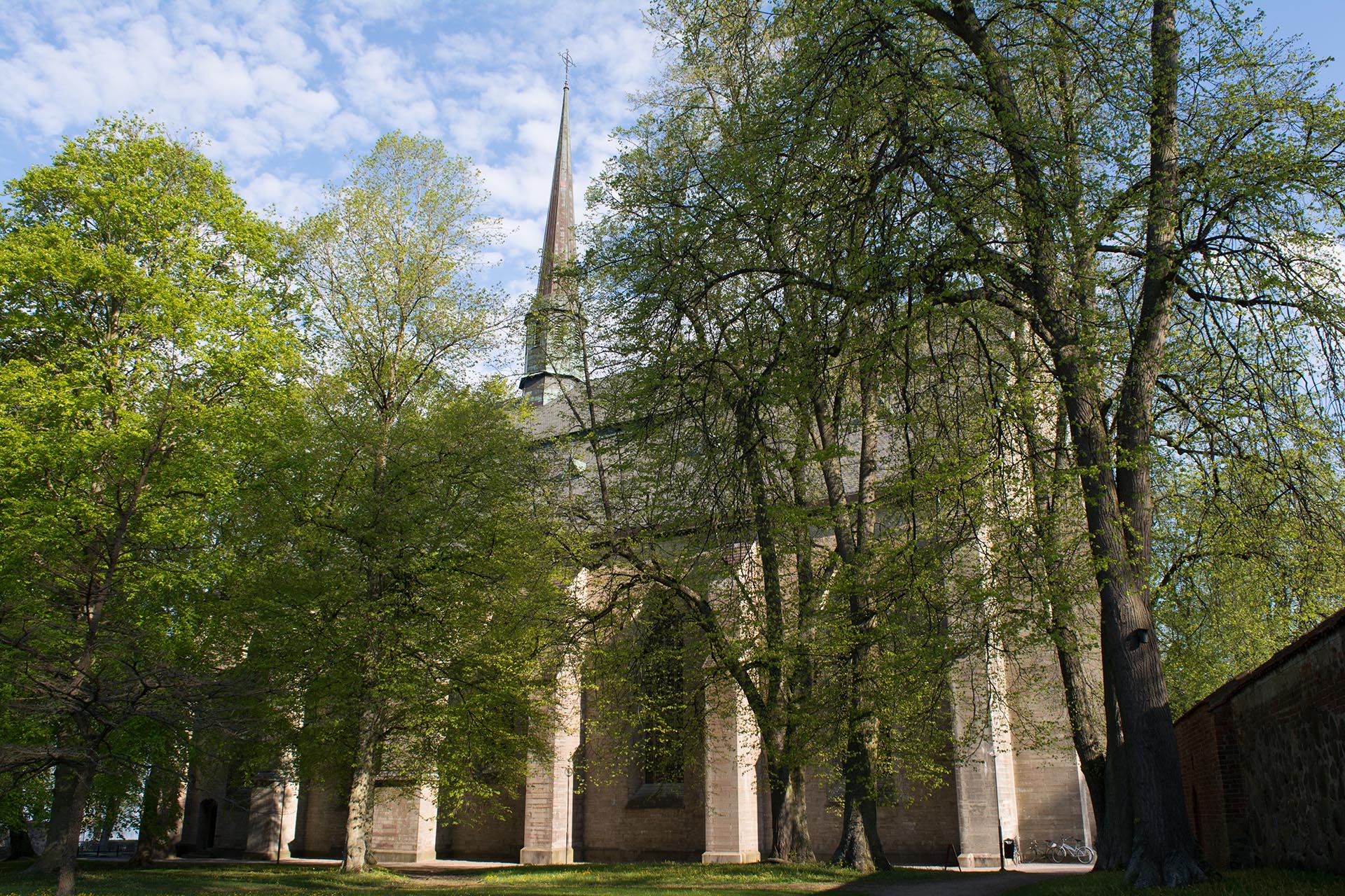 Stor stenkyrka omgiven av gröna träd.
