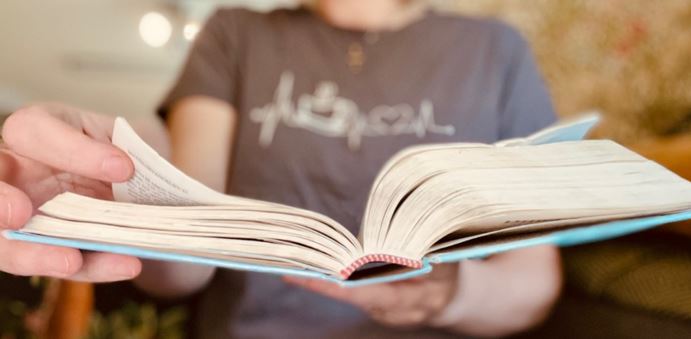 Anonym person läser i en uppslagen bibel