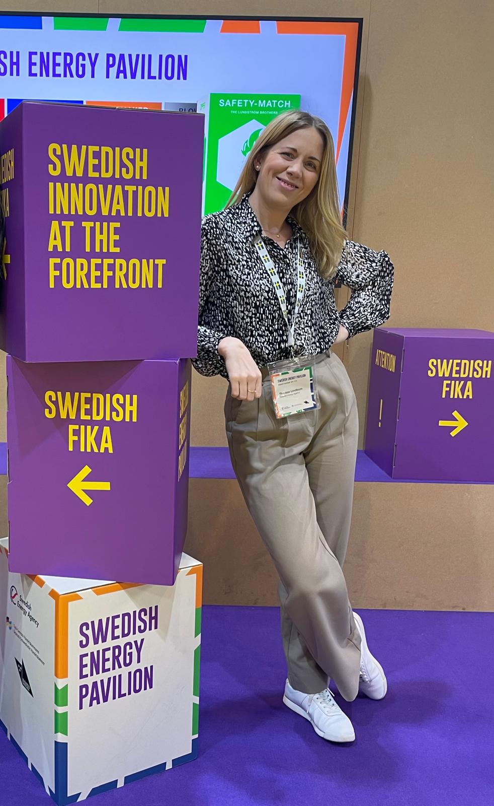 Kvinna lutar sig om några kartonger med text.