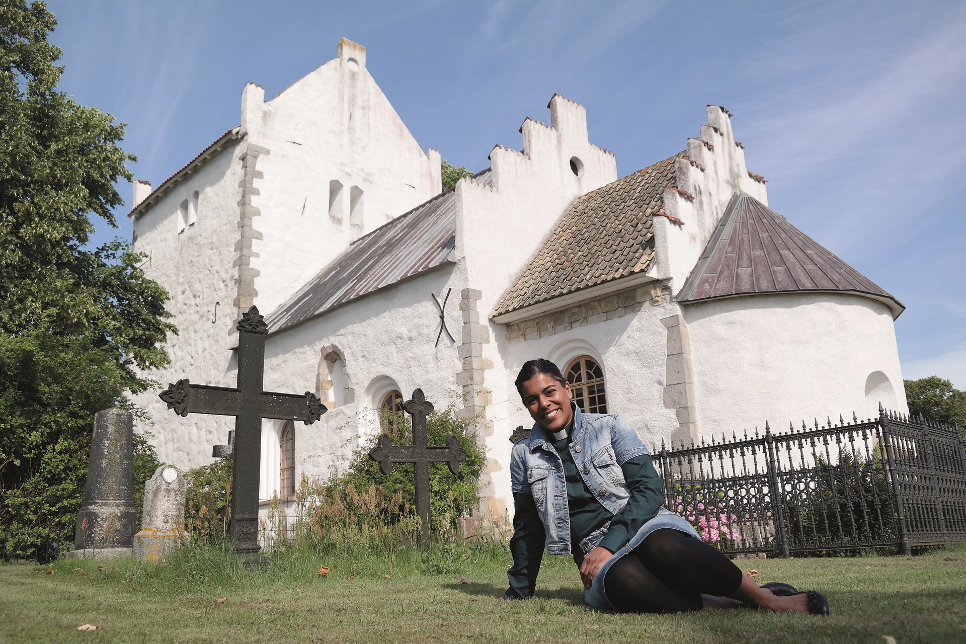 Bilden visar Anna som sitter på marken framför kors på Gamla kyrkans kyrkogård