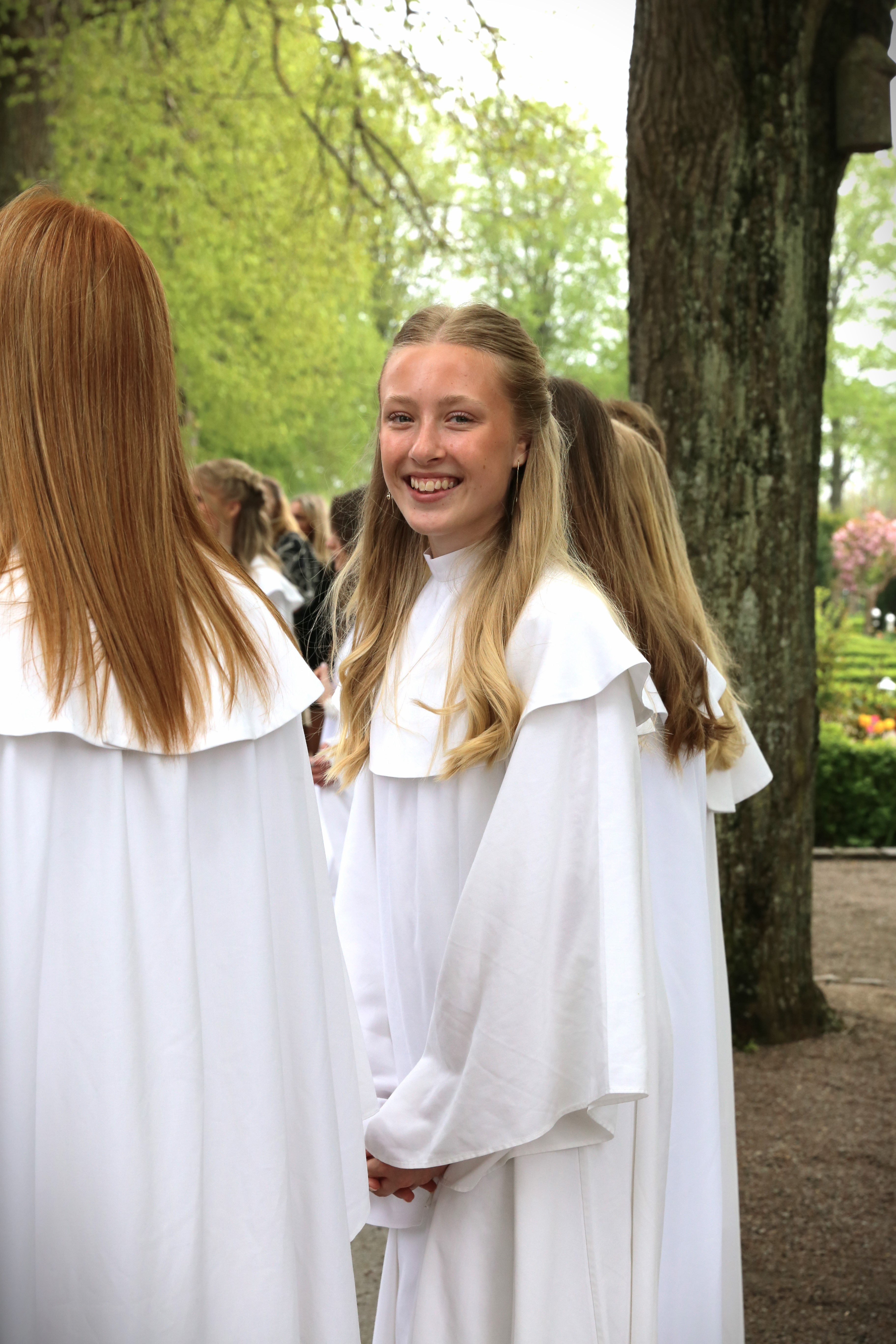 En flicka med ljust hår i konfirmanddress