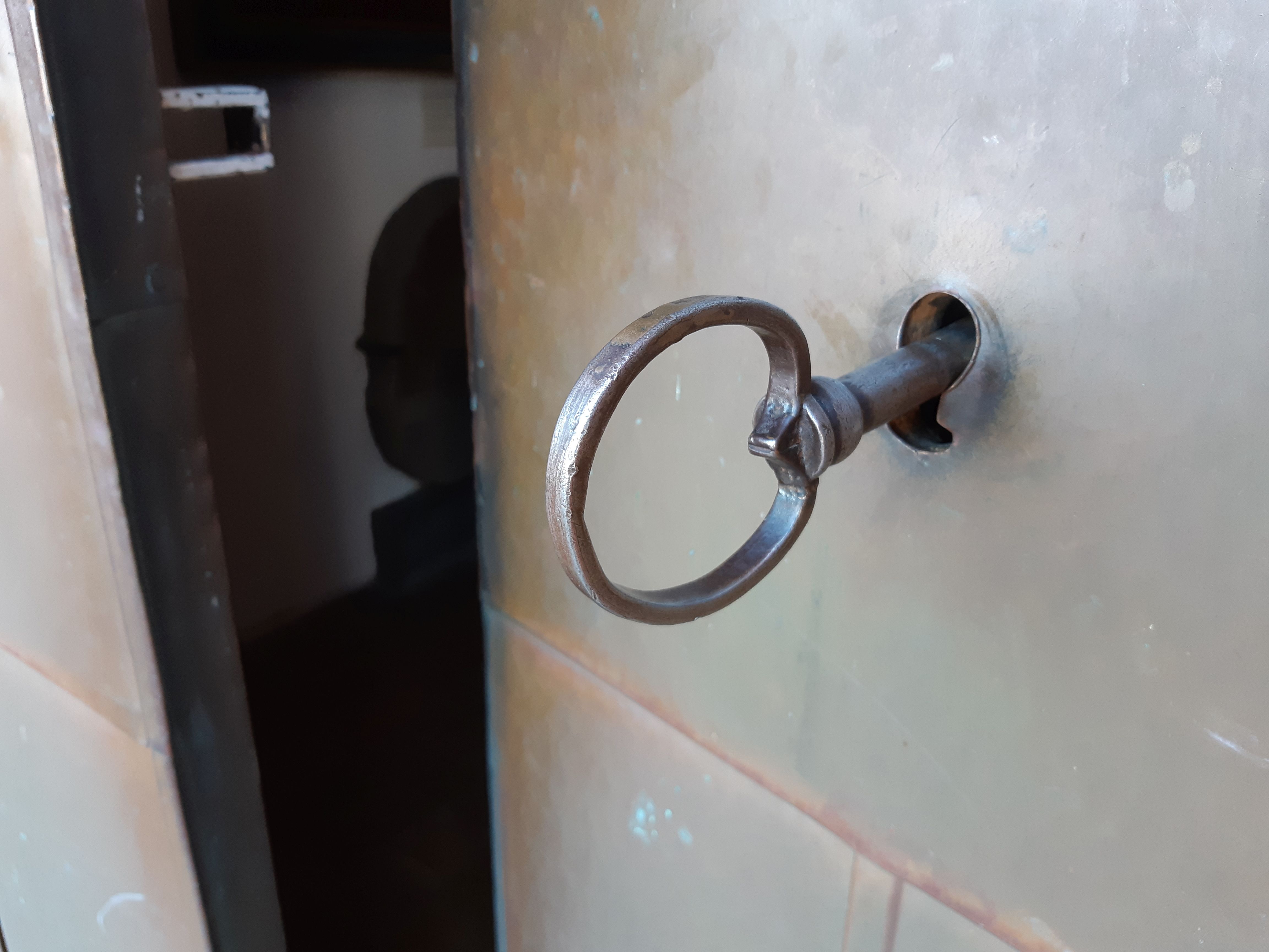 Kyrkporten till Hästveda kyrka står på glänt med en stor, gammal nyckel i låset.